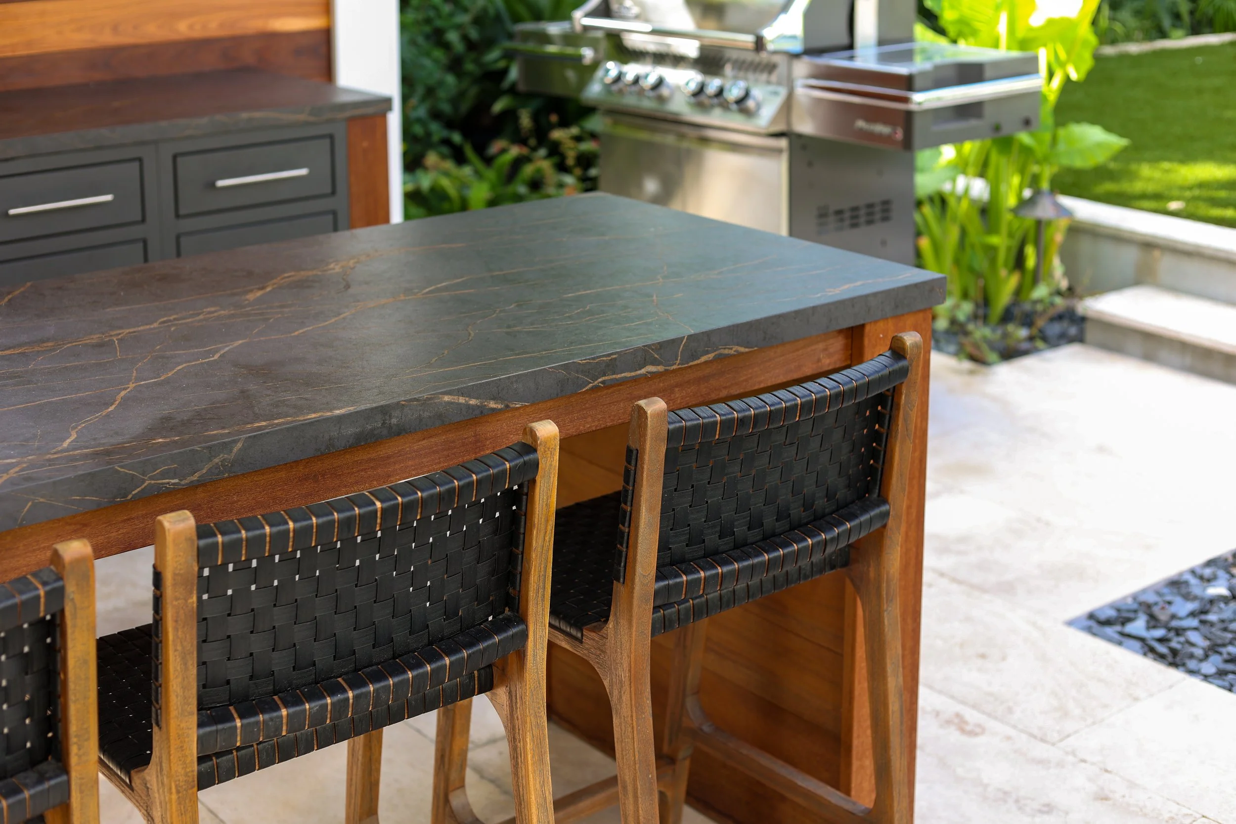Outdoor eating island with grapa wood end panels and woven barstools