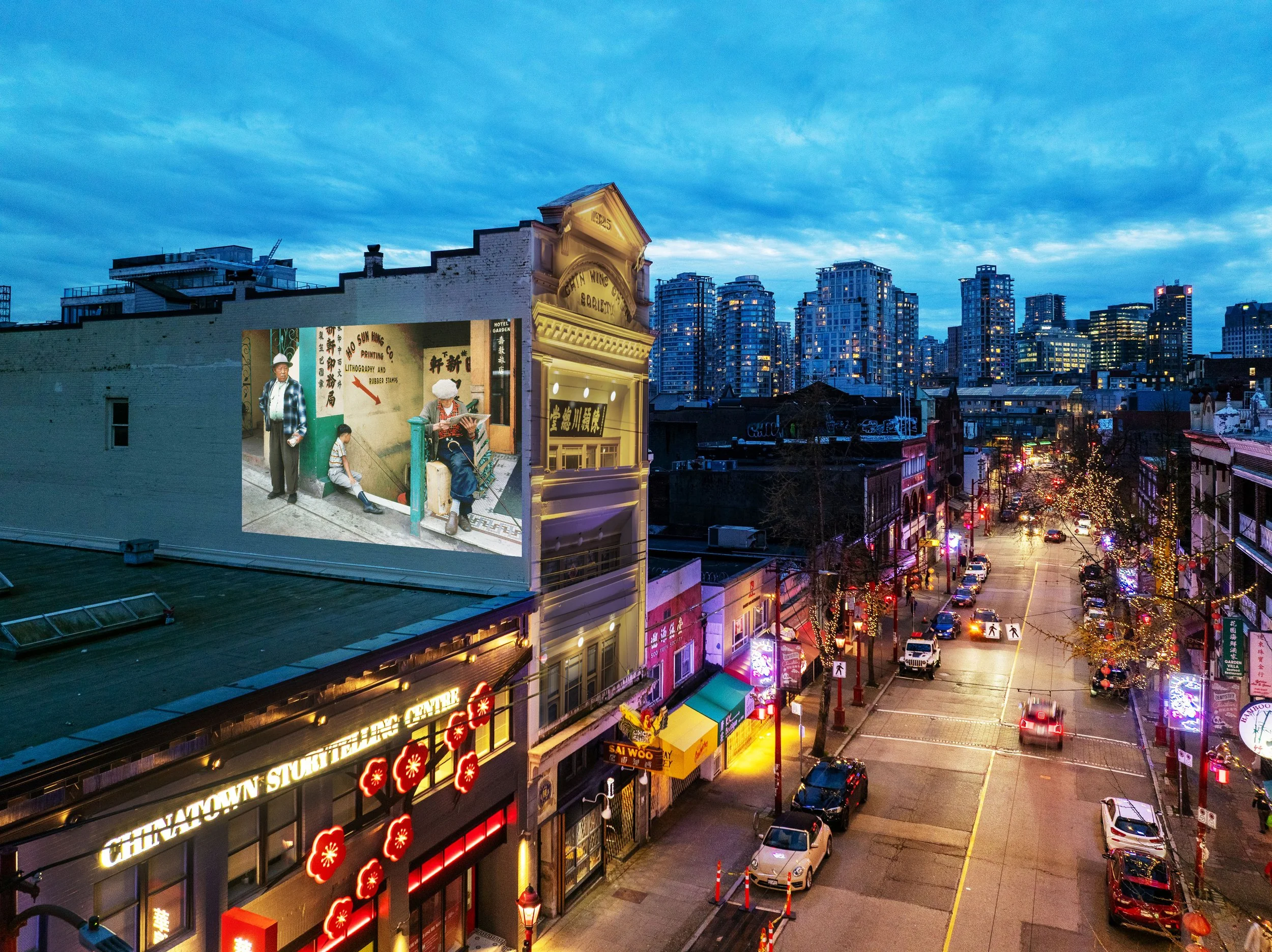 A city street scene during dusk with buildings and vibrant neon signs, including Chinese characters, and cars parked along the street, with a row of trees decorated with string lights.