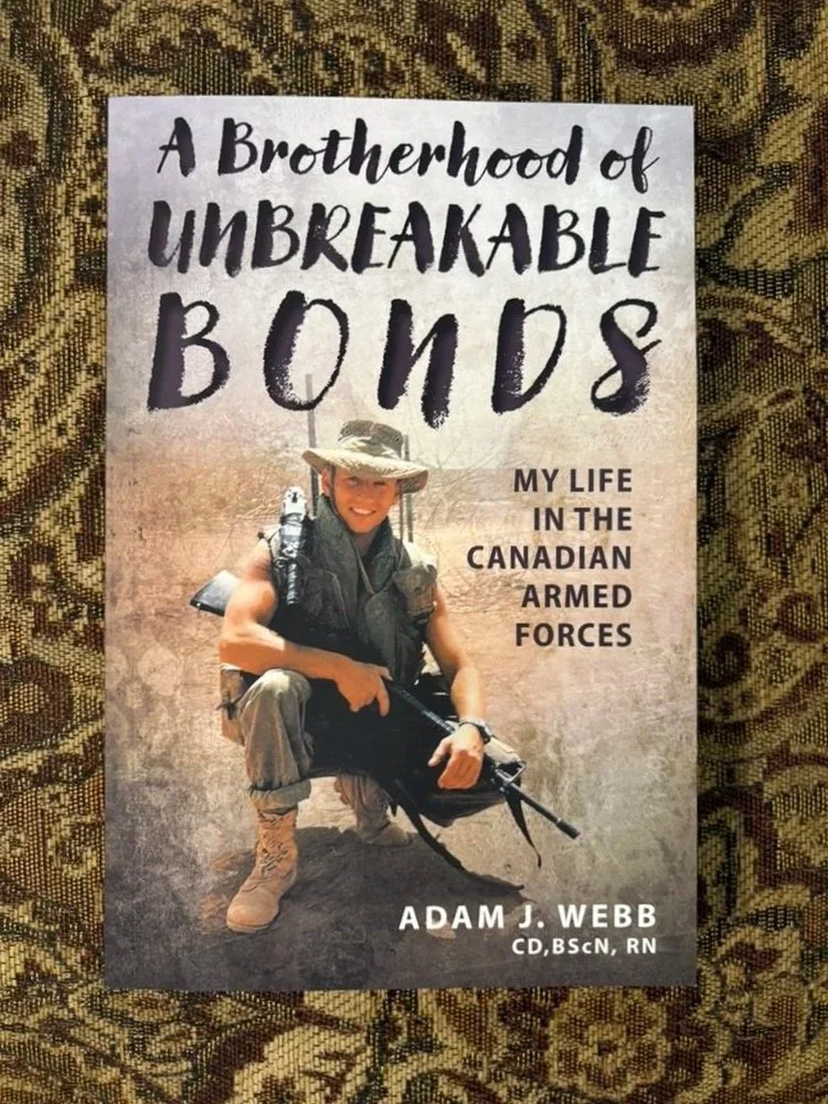 Book cover titled "A Brotherhood of Unbreakable Bonds: My Life in the Canadian Armed Forces" by Adam J. Webb, featuring Adam in military uniform with gear and a rifle, sitting in a desert landscape.