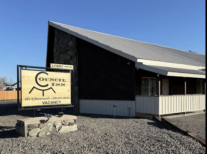 Exterior view of the Council Inn, a lodging with vacancy posted, located at 403 N Dartmouth. The building has a modern design with a sloped roof and a sign indicating the lobby entrance.
