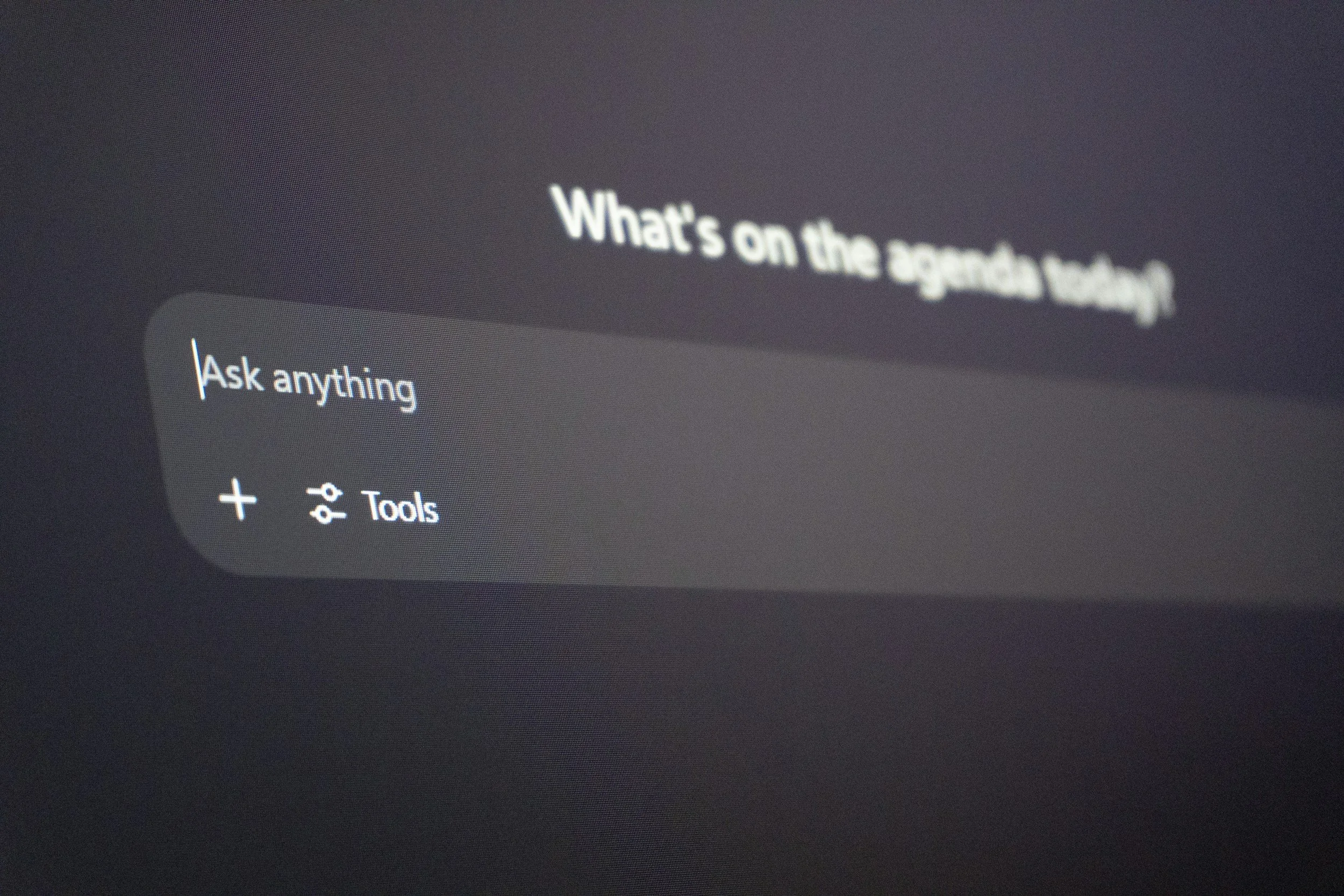 Computer screen showing text 'What's on the agenda today' and a menu with 'Ask anything' and 'Tools' options.