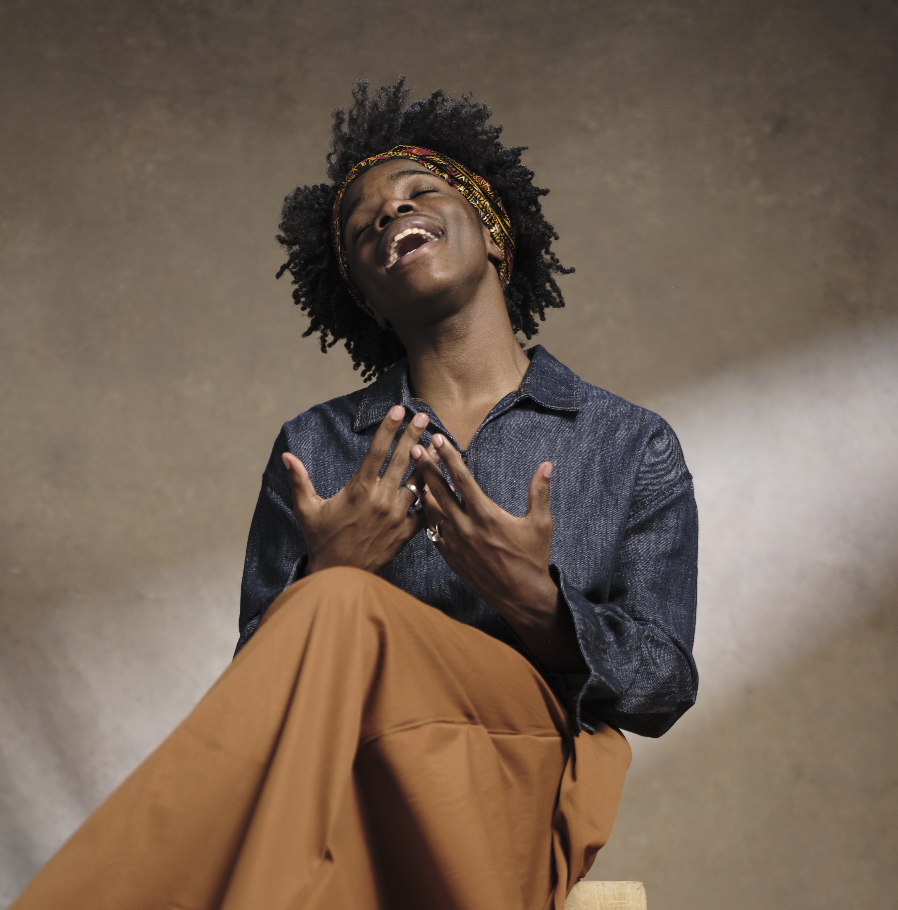 Singer and songwriter Nathanael Barlow smiling in a studio portrait