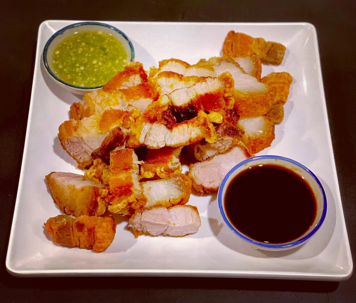 Fried chicken with dipping sauces on a white square plate