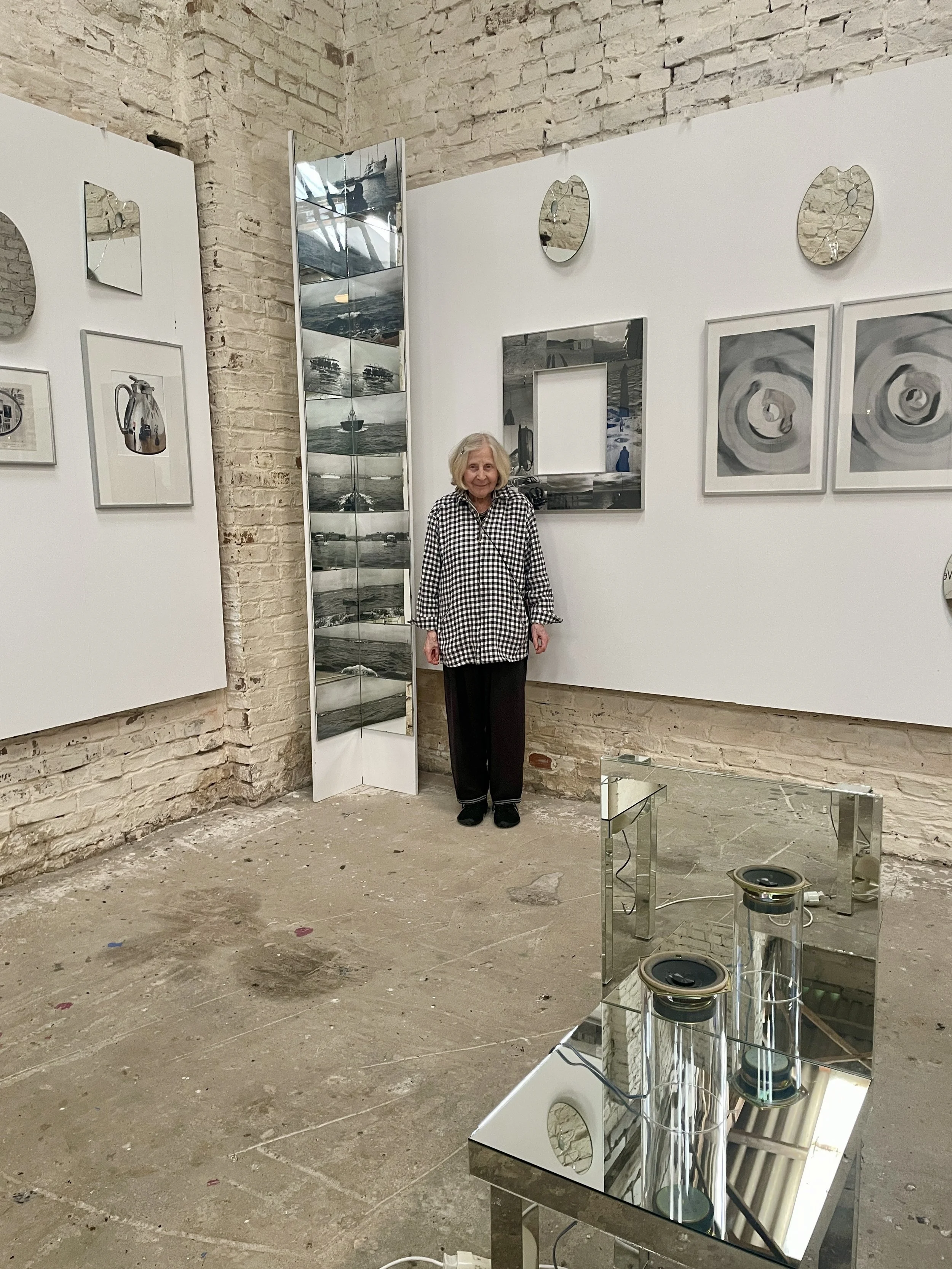 Die Berliner Künstlerin Gisela Weimann in ihrer Spiegel-Installation in der Kunsthalle Bahnitz. Spiegelobjekte und reflektierende Flächen greifen in den Ausstellungsraum aus und beziehen Umgebung und Betrachtende in die Arbeit ein.