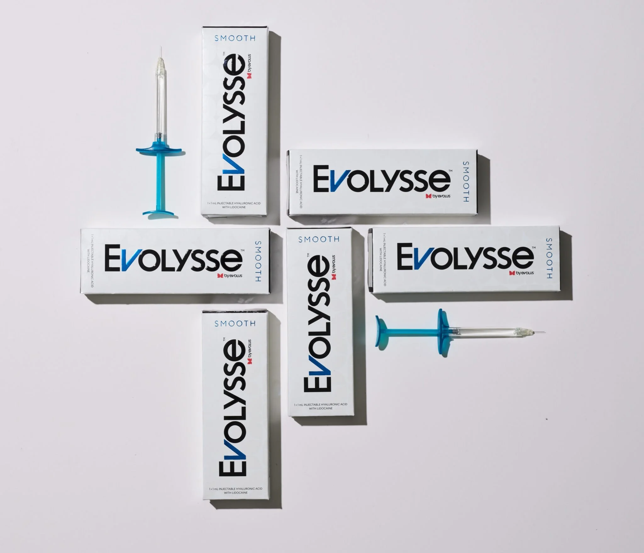 Several boxes of Evolyse hyaluronic acid injectable gel arranged on a white surface, with two syringes placed beside them.