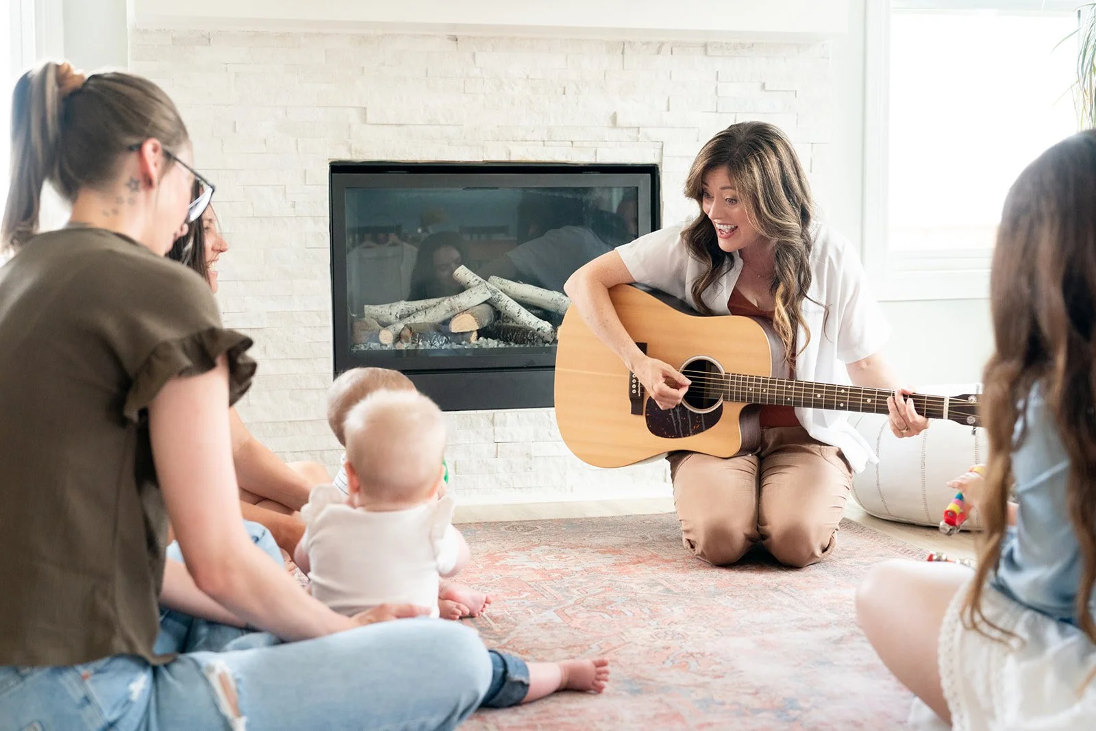 Laura MacLeod, music therapist, singing and playing guitar for babies and their parents