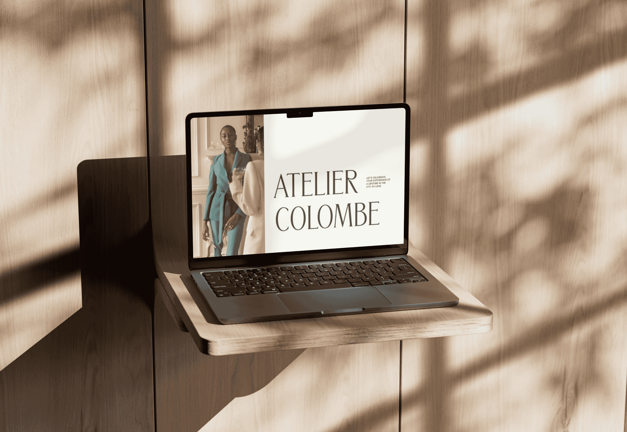 Mockup of Atelier Colombe's hero section, featured on a laptop with a wooden backdrop.