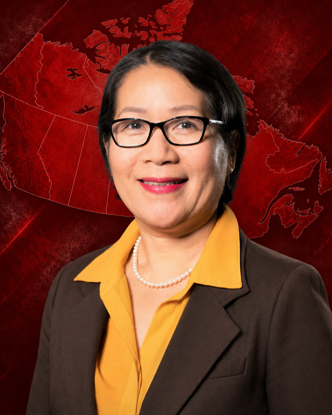 Portrait of a woman wearing glasses, a brown blazer, and a yellow blouse, smiling against a gray background.