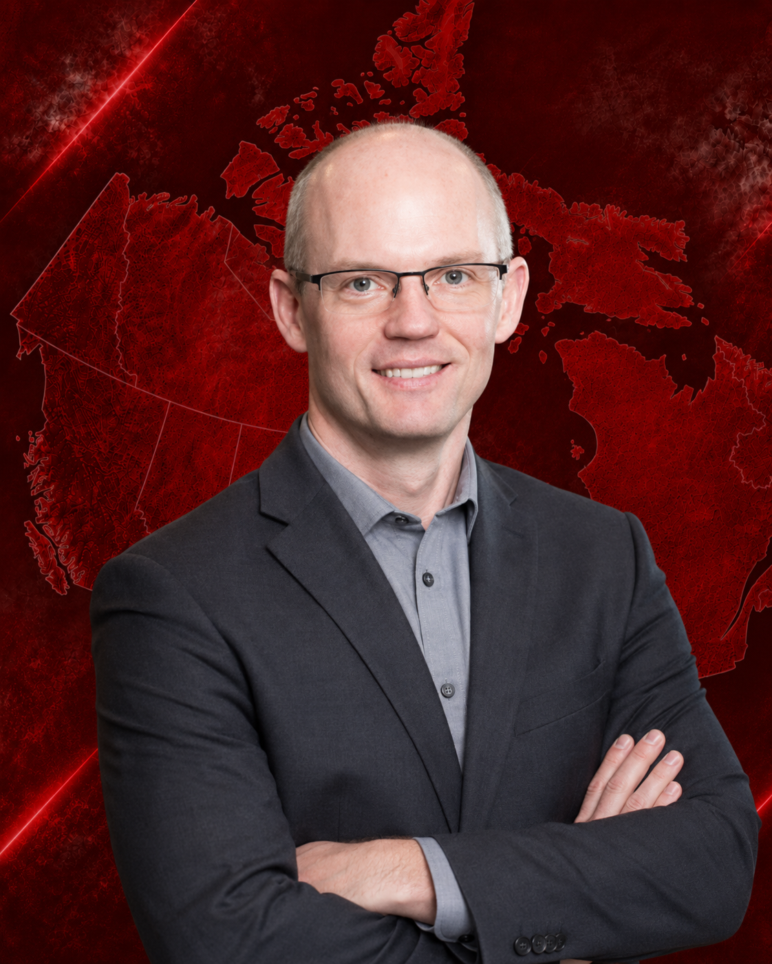 A man in a suit and glasses smiling with arms crossed in front of a red map of Canada background.