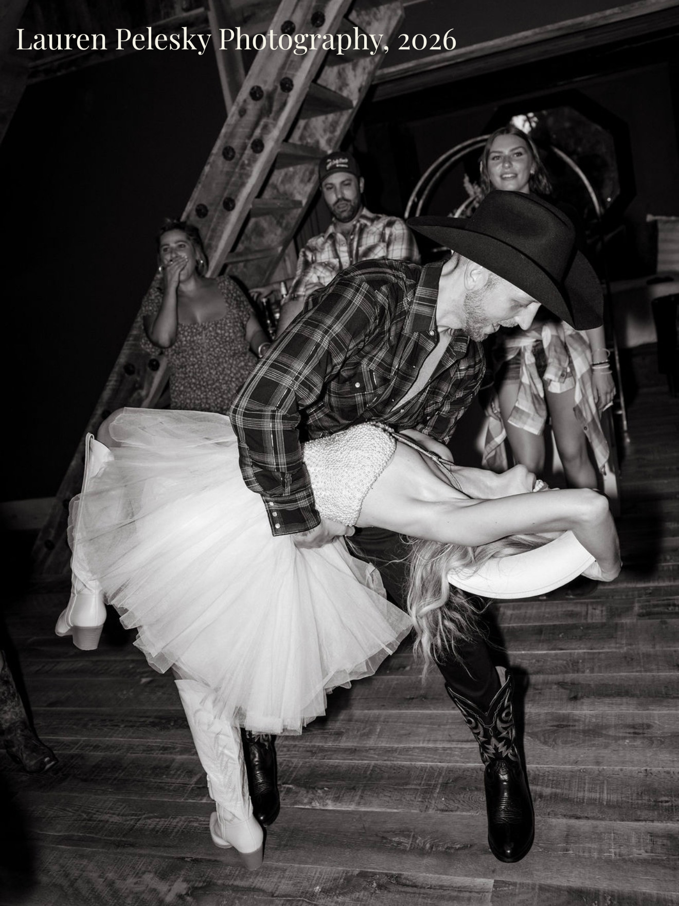 A groom in a cowboy hat and boots dances with his bride in a short, white dress at a wedding farewell party in Franklin, Tennessee.