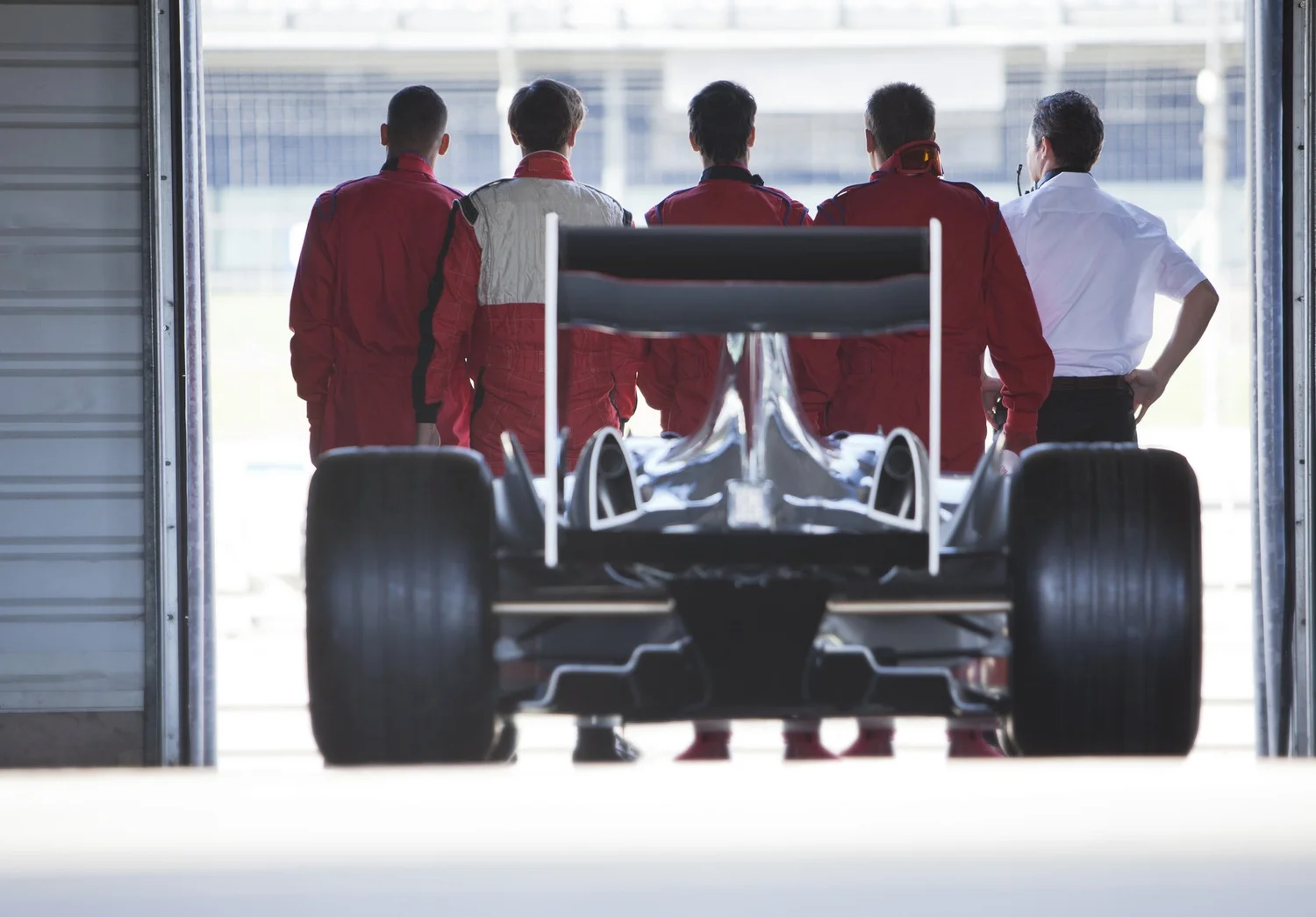 Race team moving in sync around a car