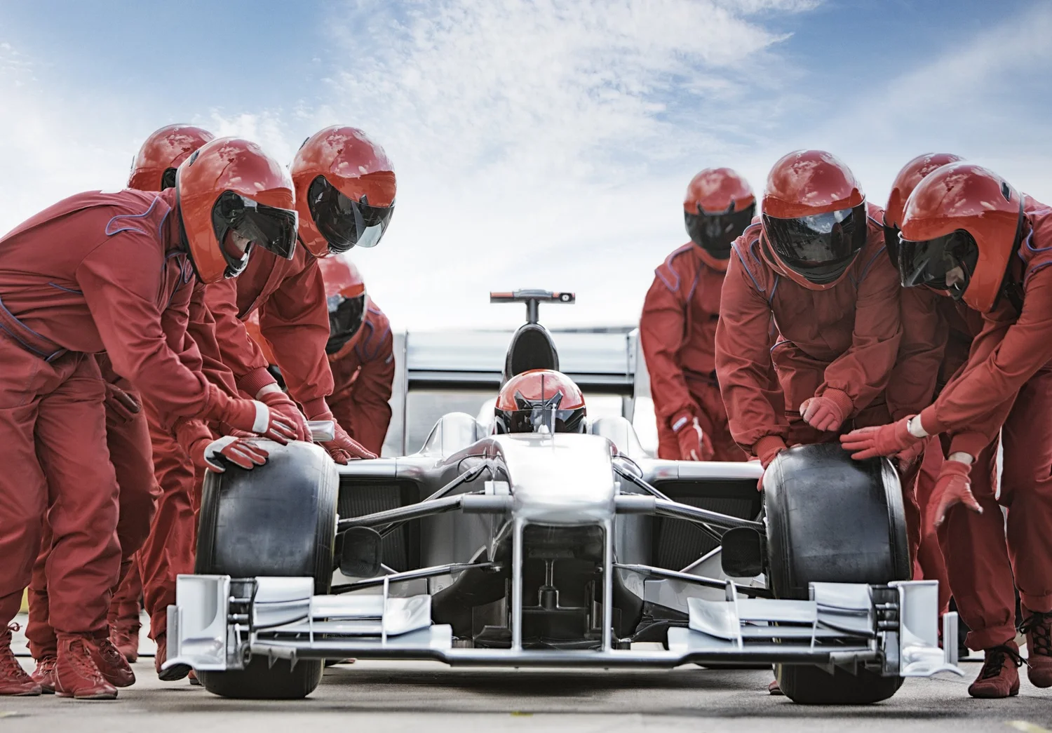 Pit crew working together around a race car