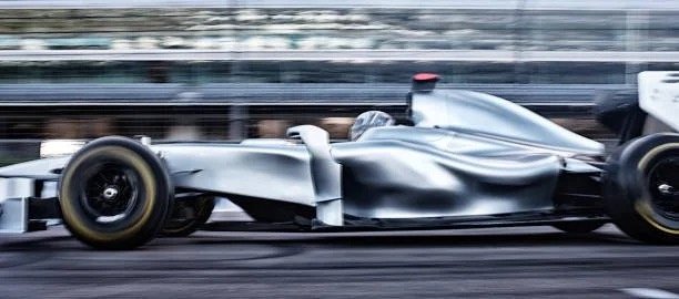 Silver Formula 1 race car on a racetrack in motion