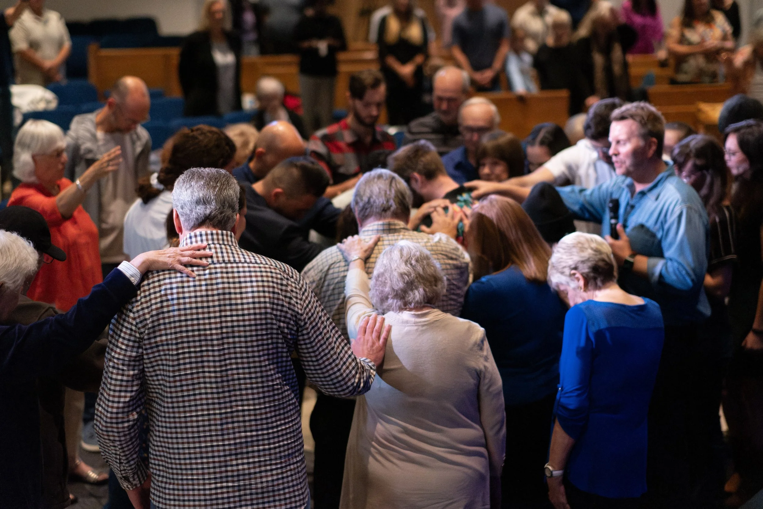 People praying and holding hands in a church during a religious service.
