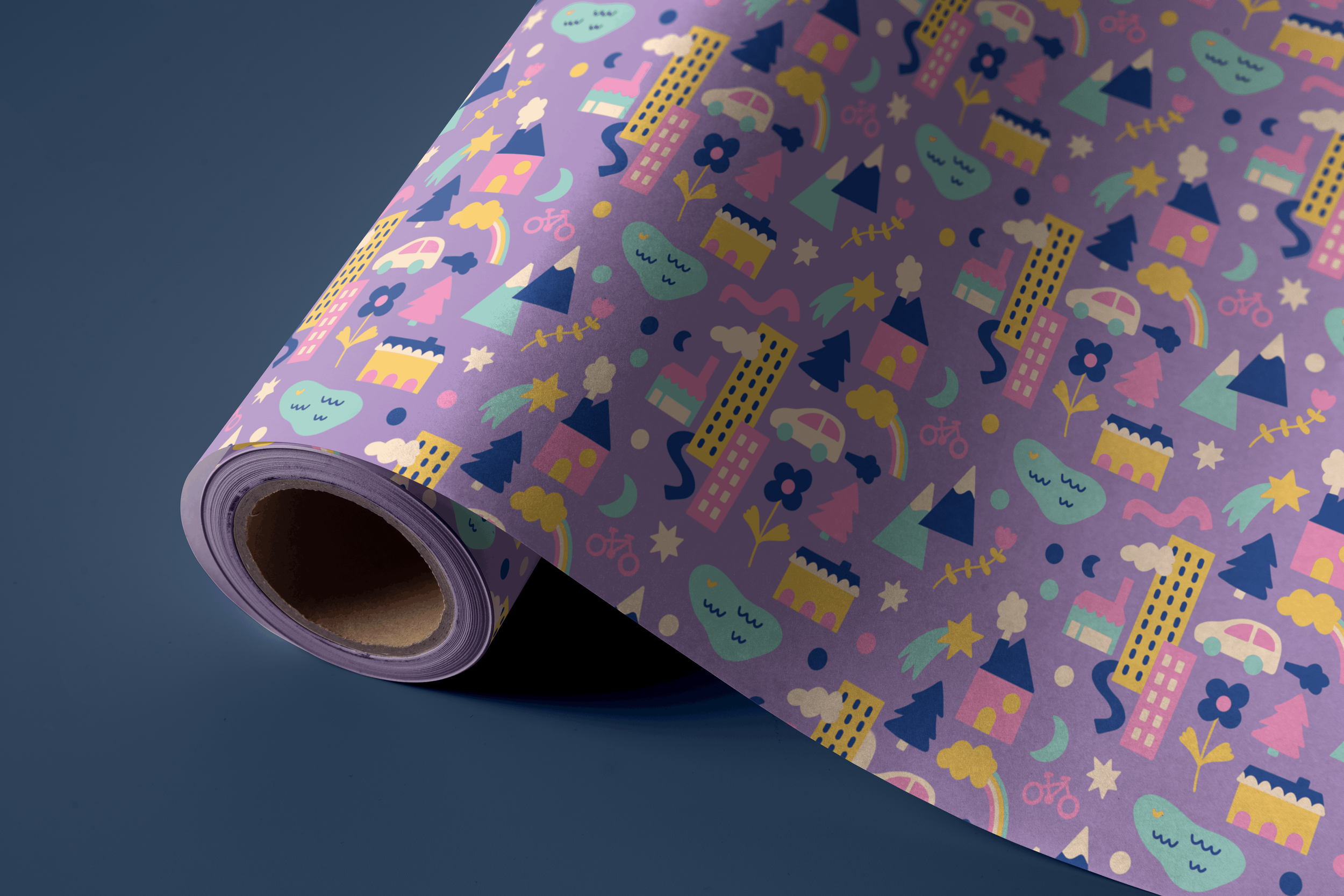 A roll of decorative purple wrapping paper with colorful illustrations of houses, trees, rainbows, clouds, stars, mountains, and bicycles on a blue background.