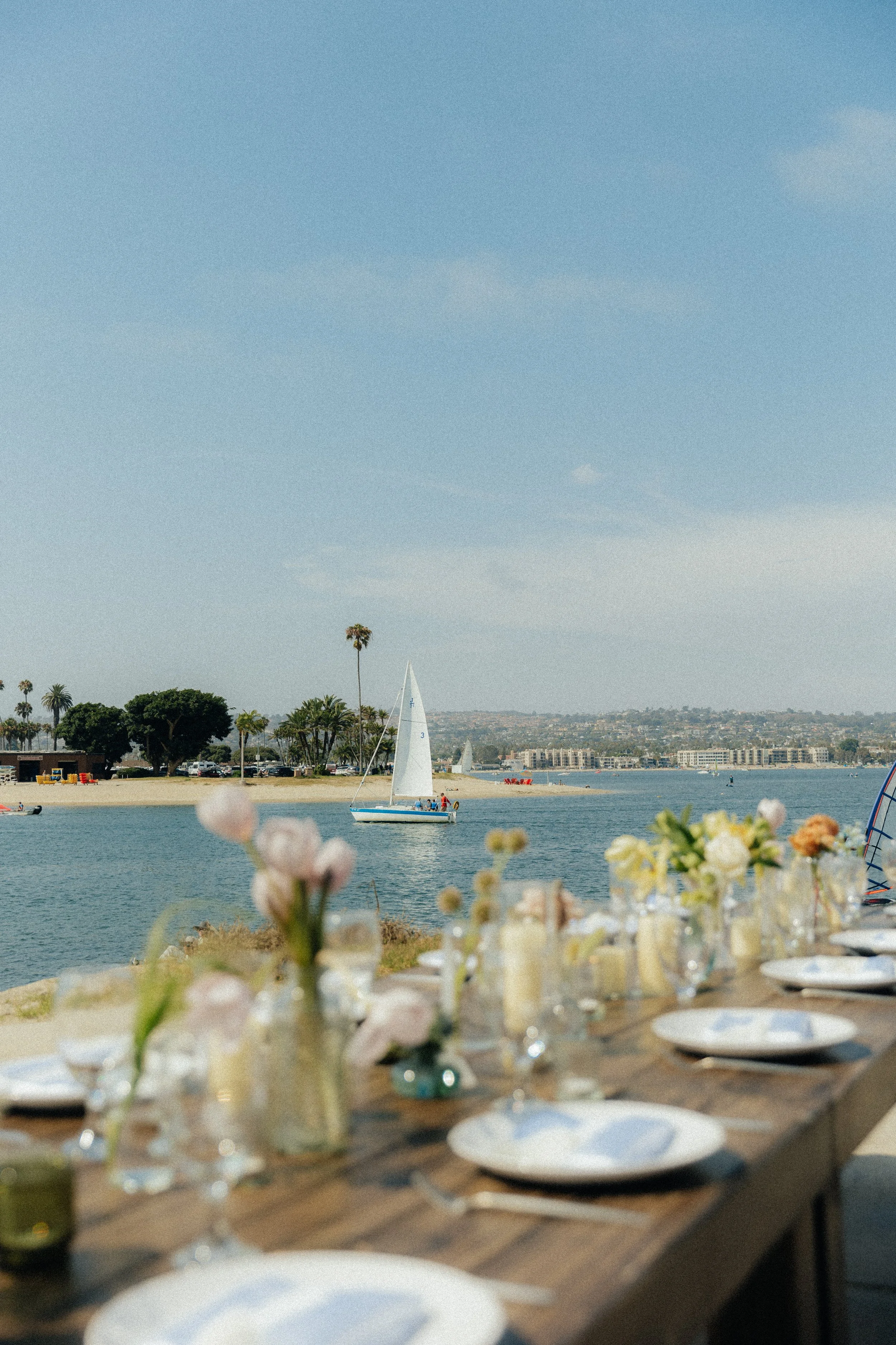 Seaside wedding reception with sailboat in the background