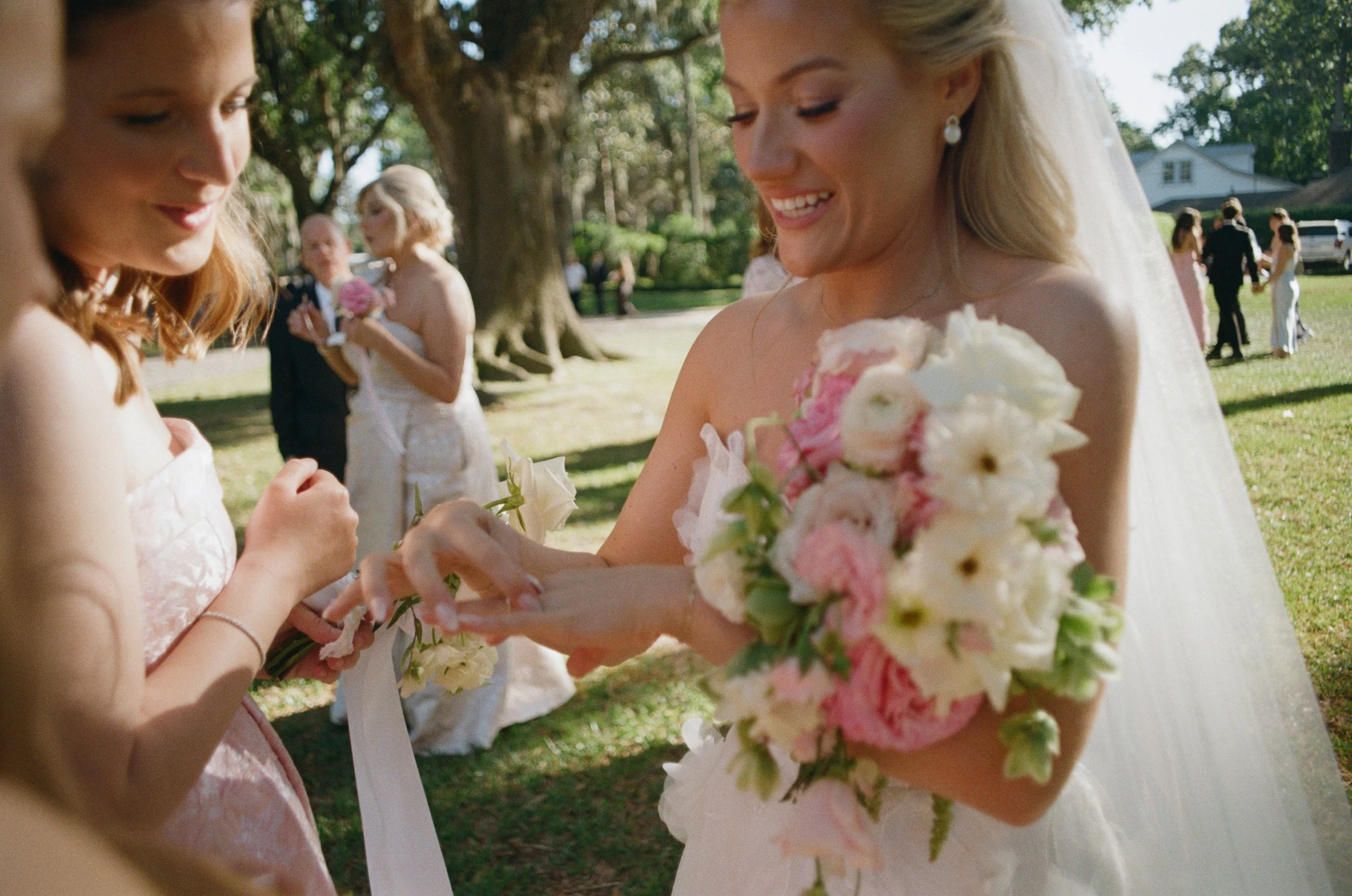 Bright coloured film image of bride showing wedding guest her ring
