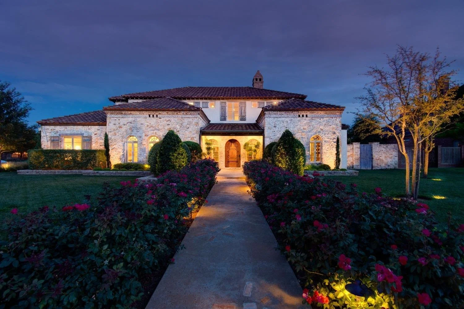 Stone home photographed at twilight.