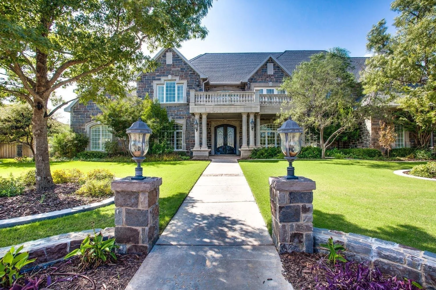 Stone home with landscaped gardens.
