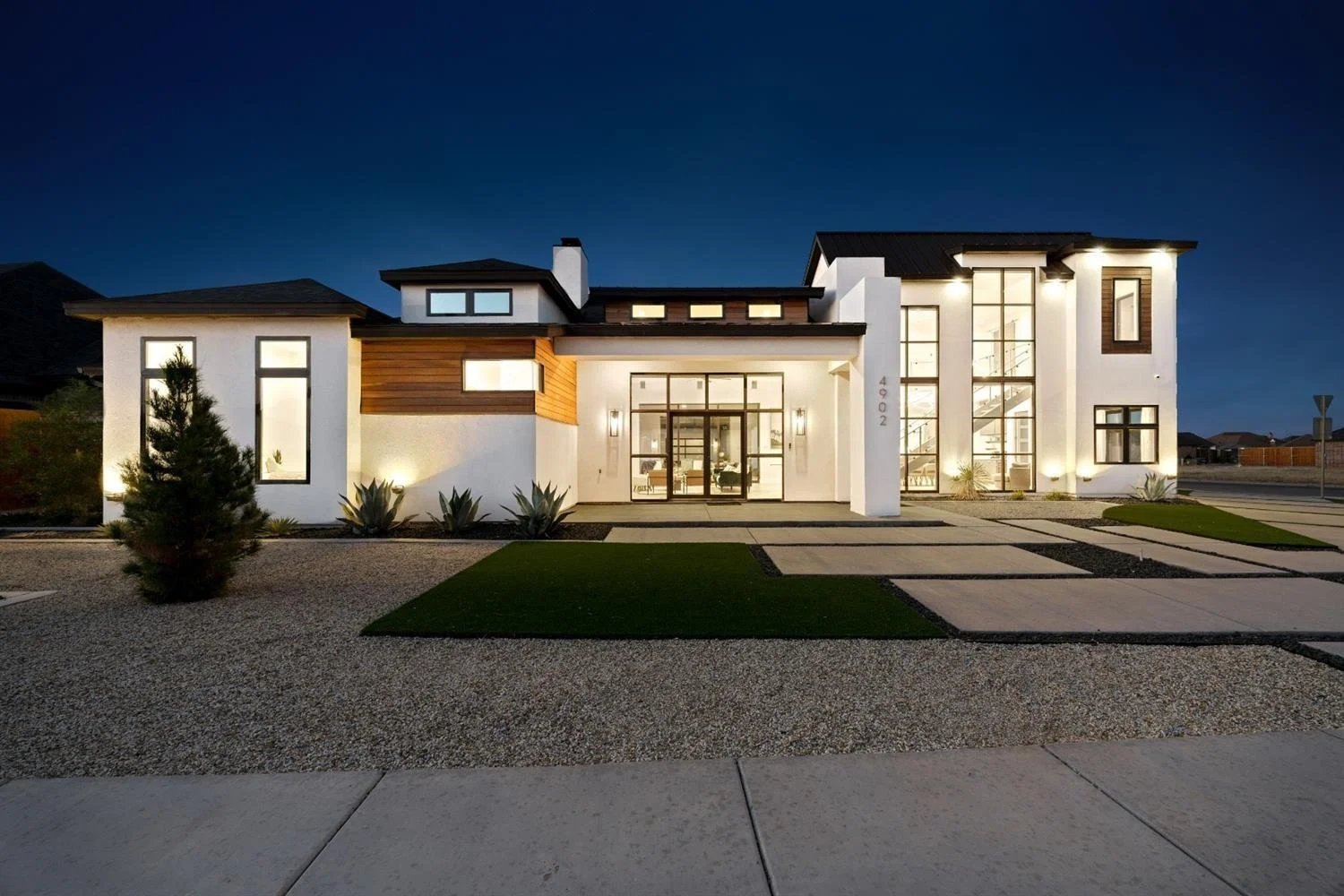 Modern home with large windows at twilight.