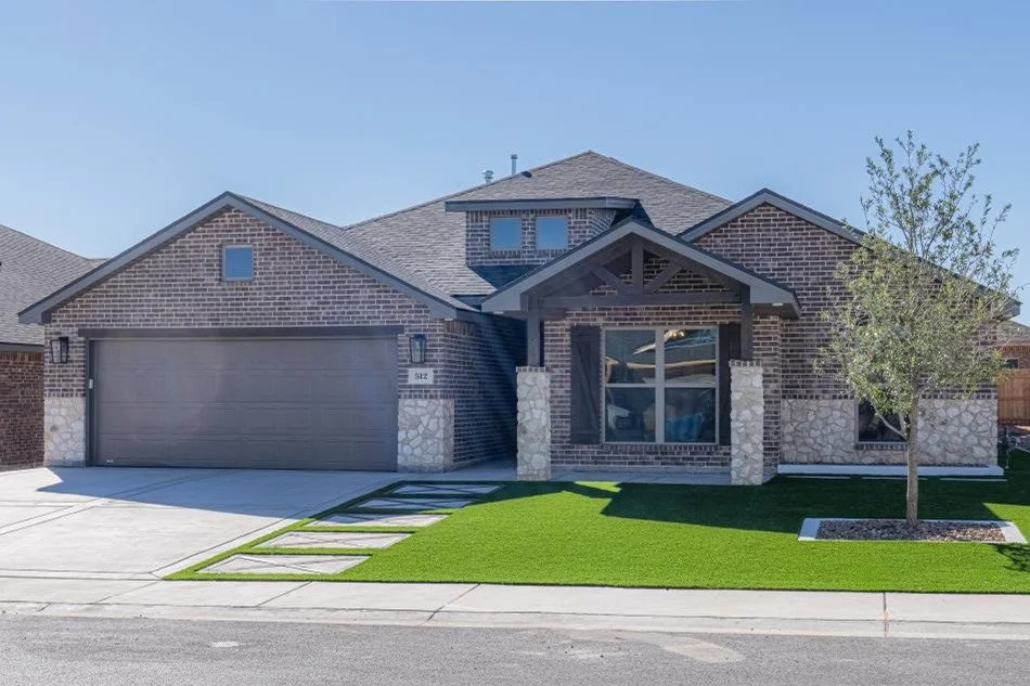 Gray-brick Betenbough home with stone accents and a two-car garage.