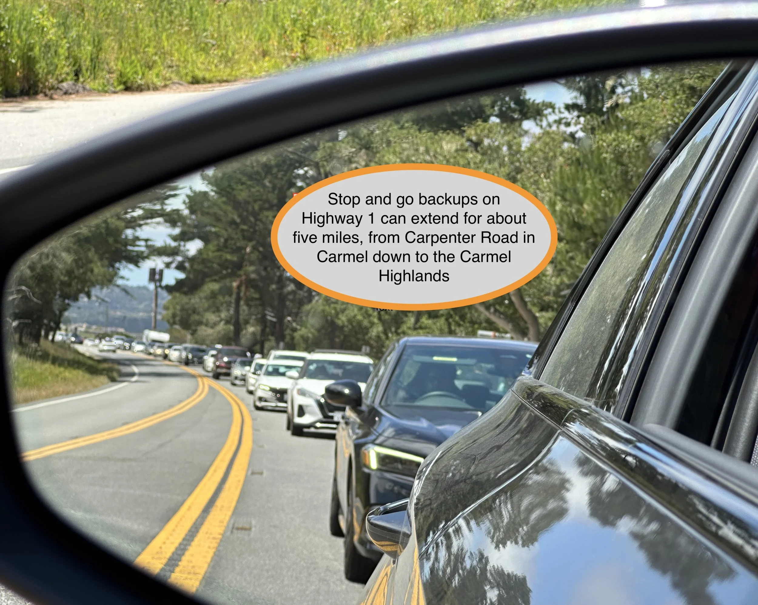A long line of traffic, extending for miles, as seen in a vehicle side mirror.