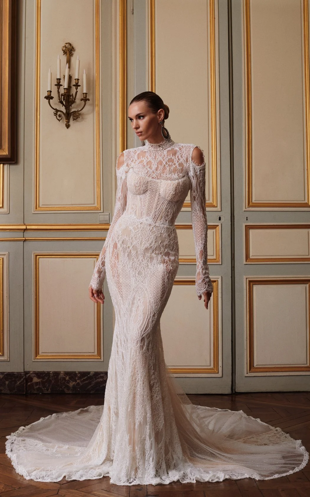 Model wearing a Galia Lahav long-sleeve lace fit-and-flare wedding dress featuring a high mock neckline, elegant cold-shoulder cutouts, a sheer corset bodice, and a detailed lace train
