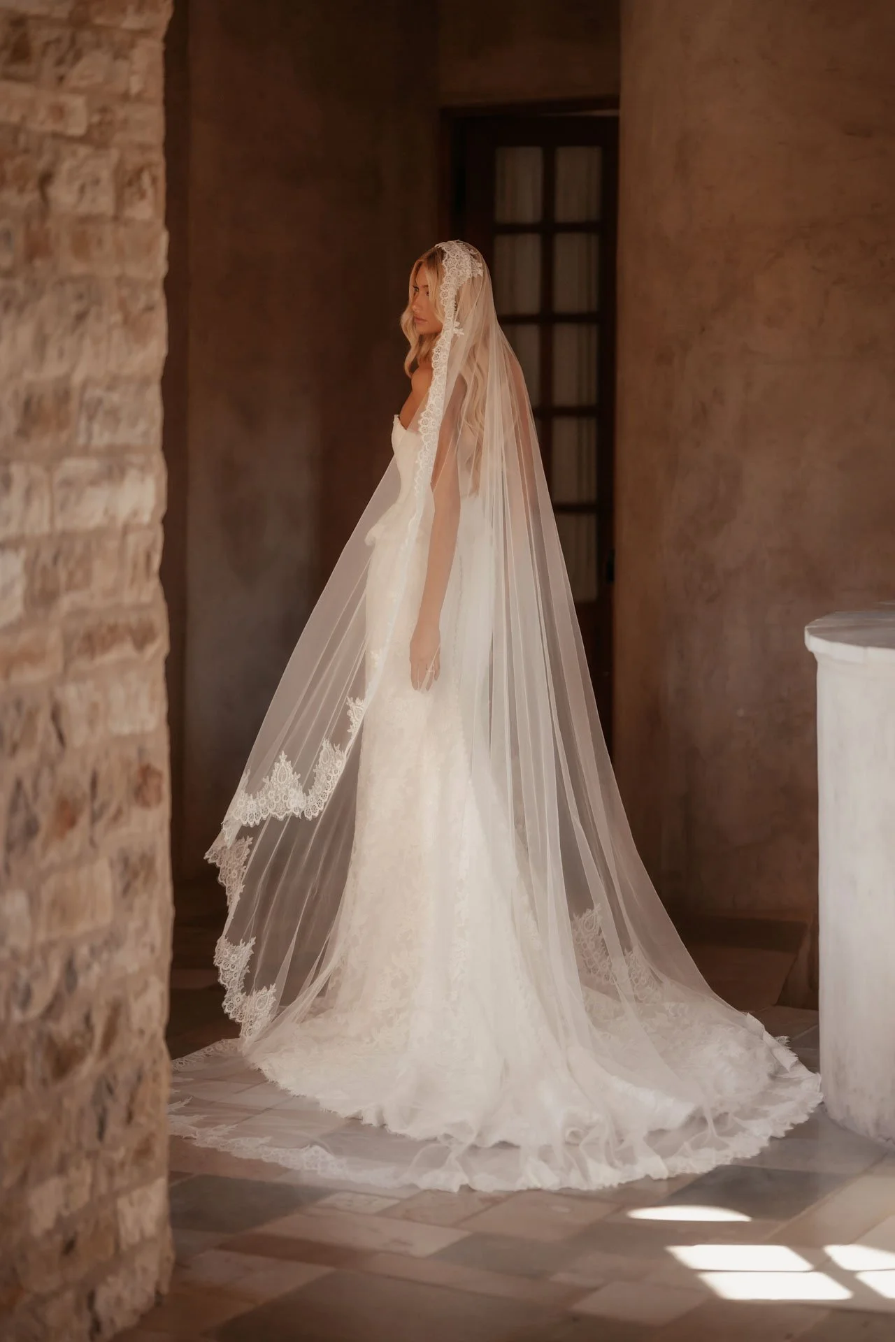 Model wearing a Martina Liana wedding dress with a long elegant veil in an italian villa. 