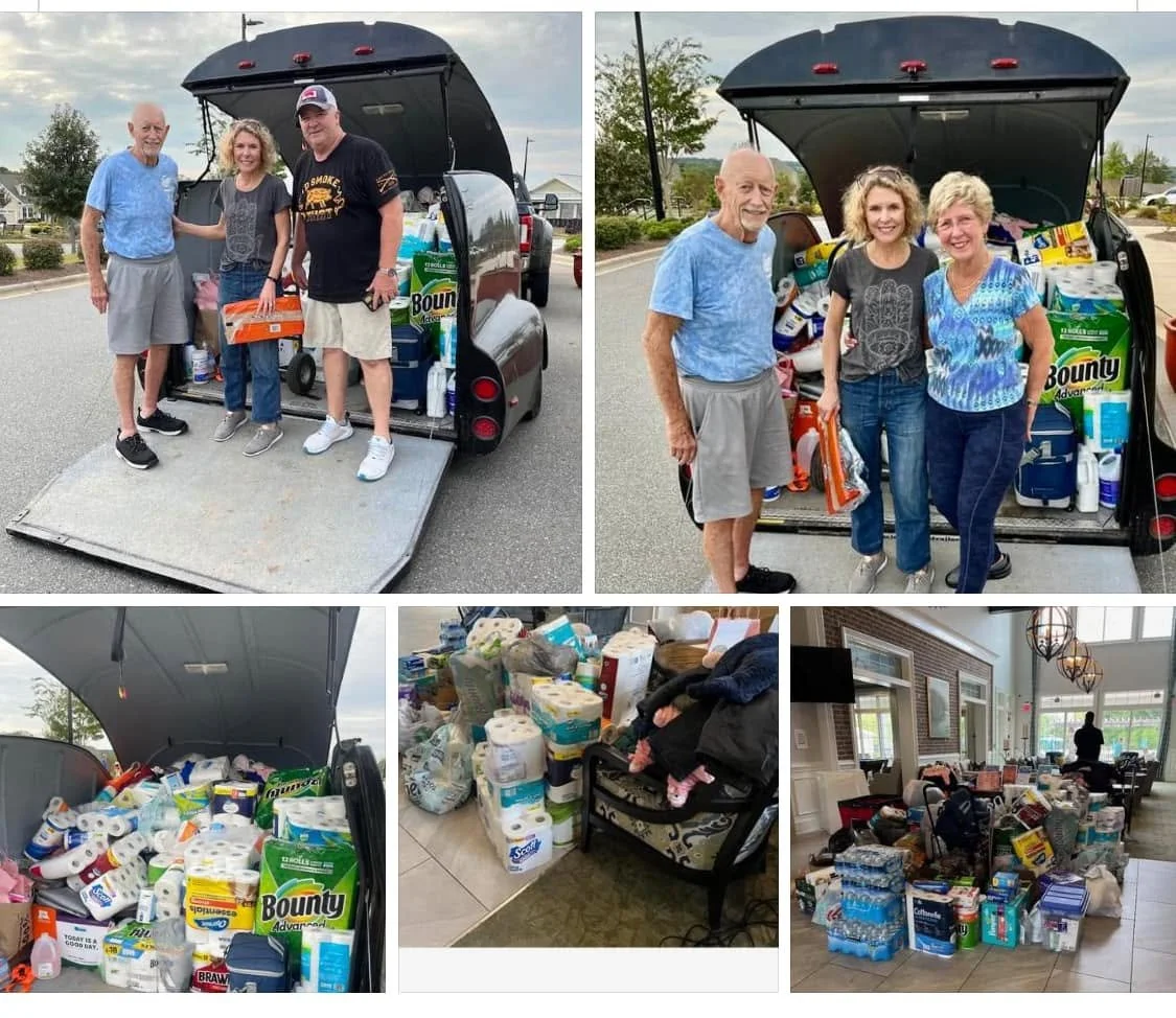 People unloading donations, including household supplies and paper products, from a vehicle and sorting them inside a house.