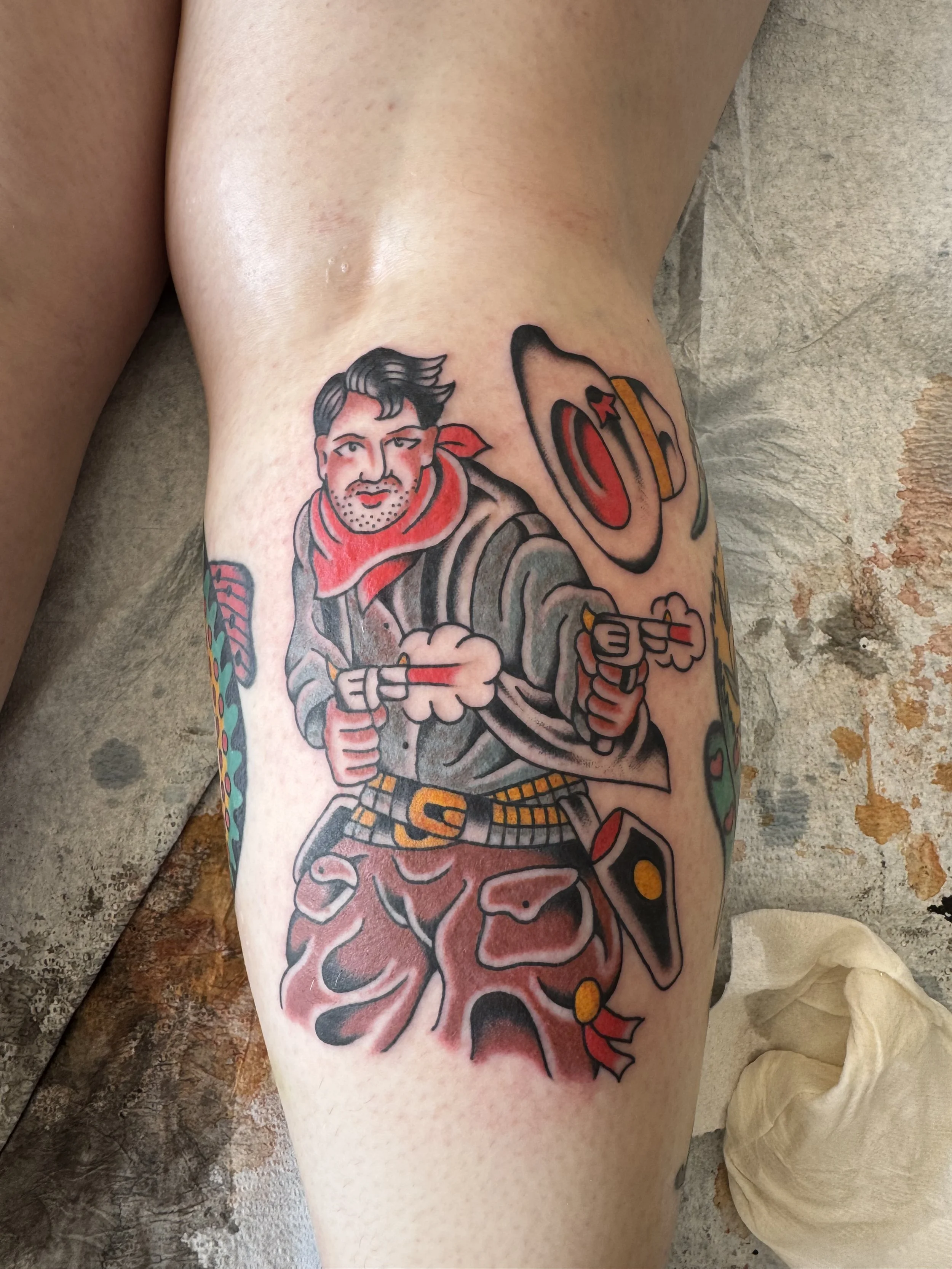Tattoo of a man in a military uniform holding a rifle, with a background of a large brain and a grenade on the other arm.