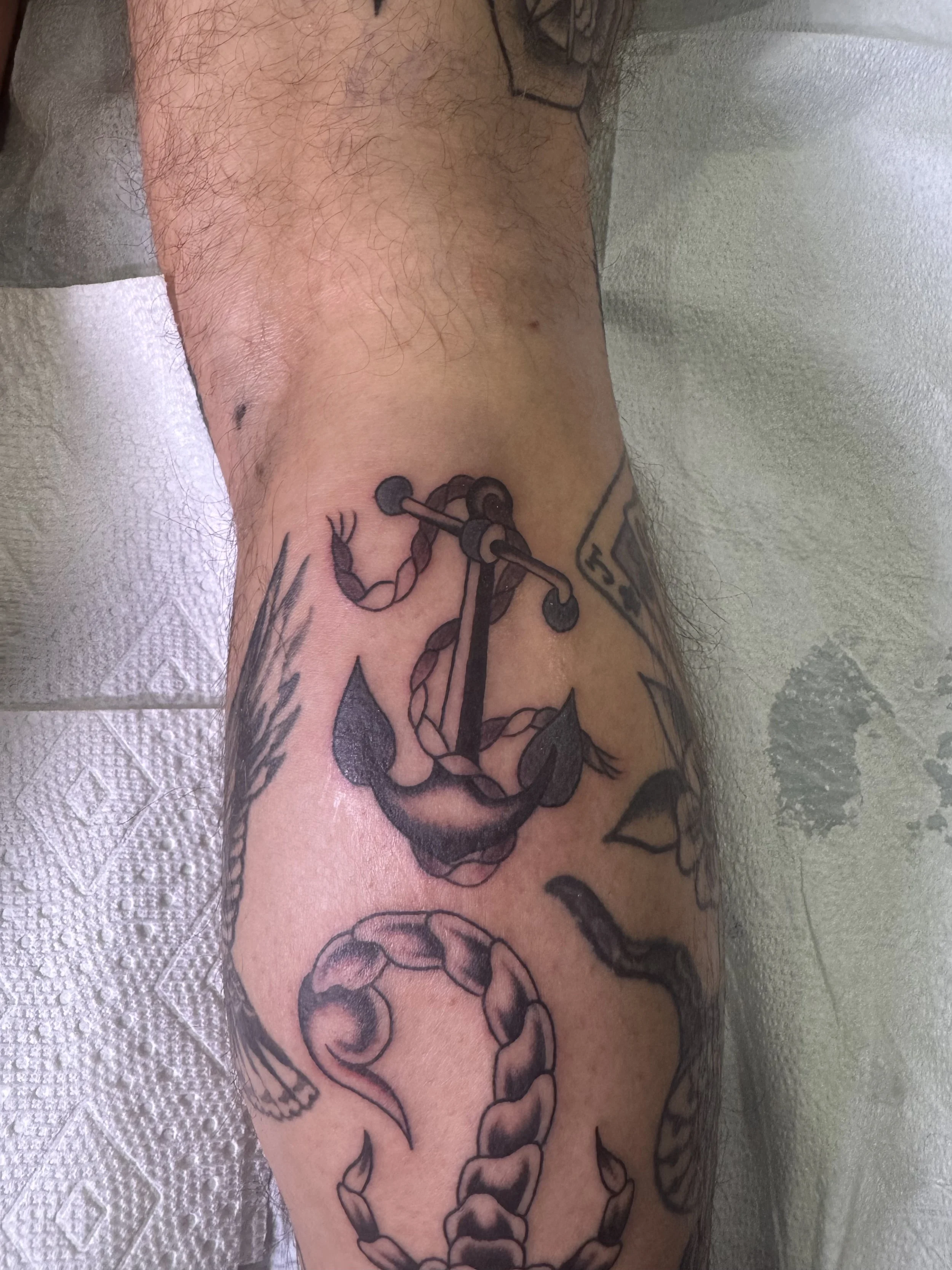 Tattoo of a snake coiled around a dagger on a person's arm