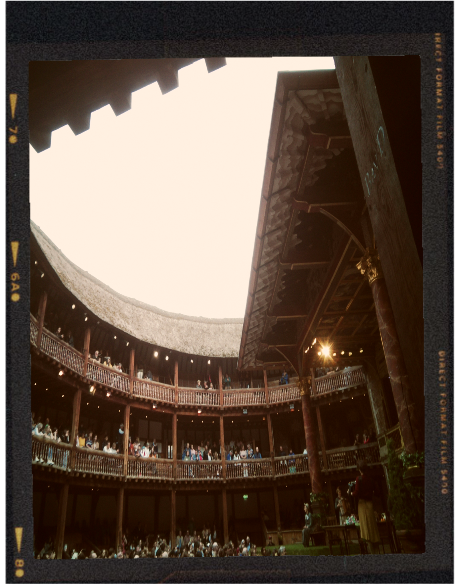 Interior view of an arena with multiple levels of balconies filled with people, and a large open ceiling with visible wooden beams and a drum above.
