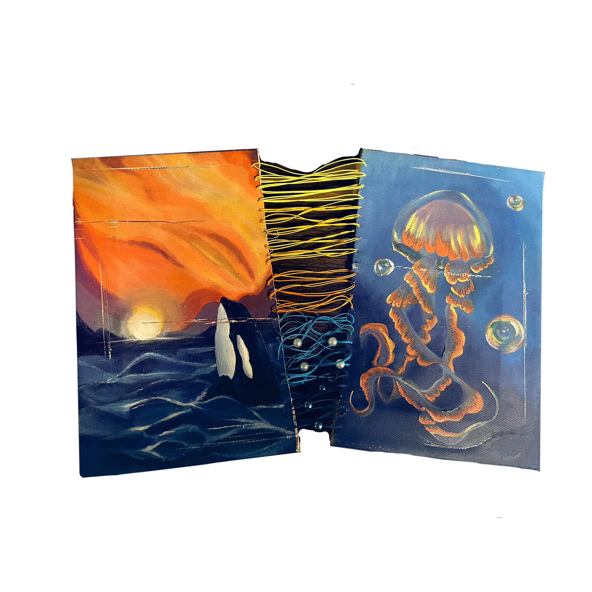 Two small sketchbooks or notebooks with ocean and sunset designs, held together by yellow and blue string.