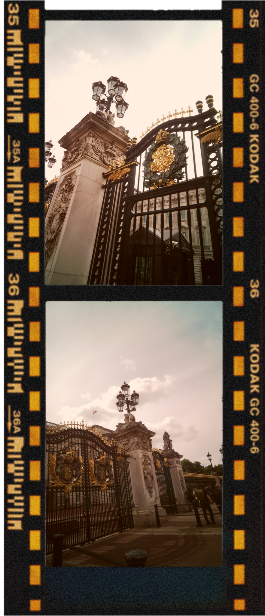 Photograph of an ornate black and gold gate with decorative gold crest, flanked by stone columns with sculptures and lanterns, leading to a historic building with a flag flying, under a partly cloudy sky.