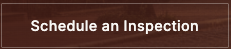 A brown sign with white text that reads 'Schedule an Inspection'.