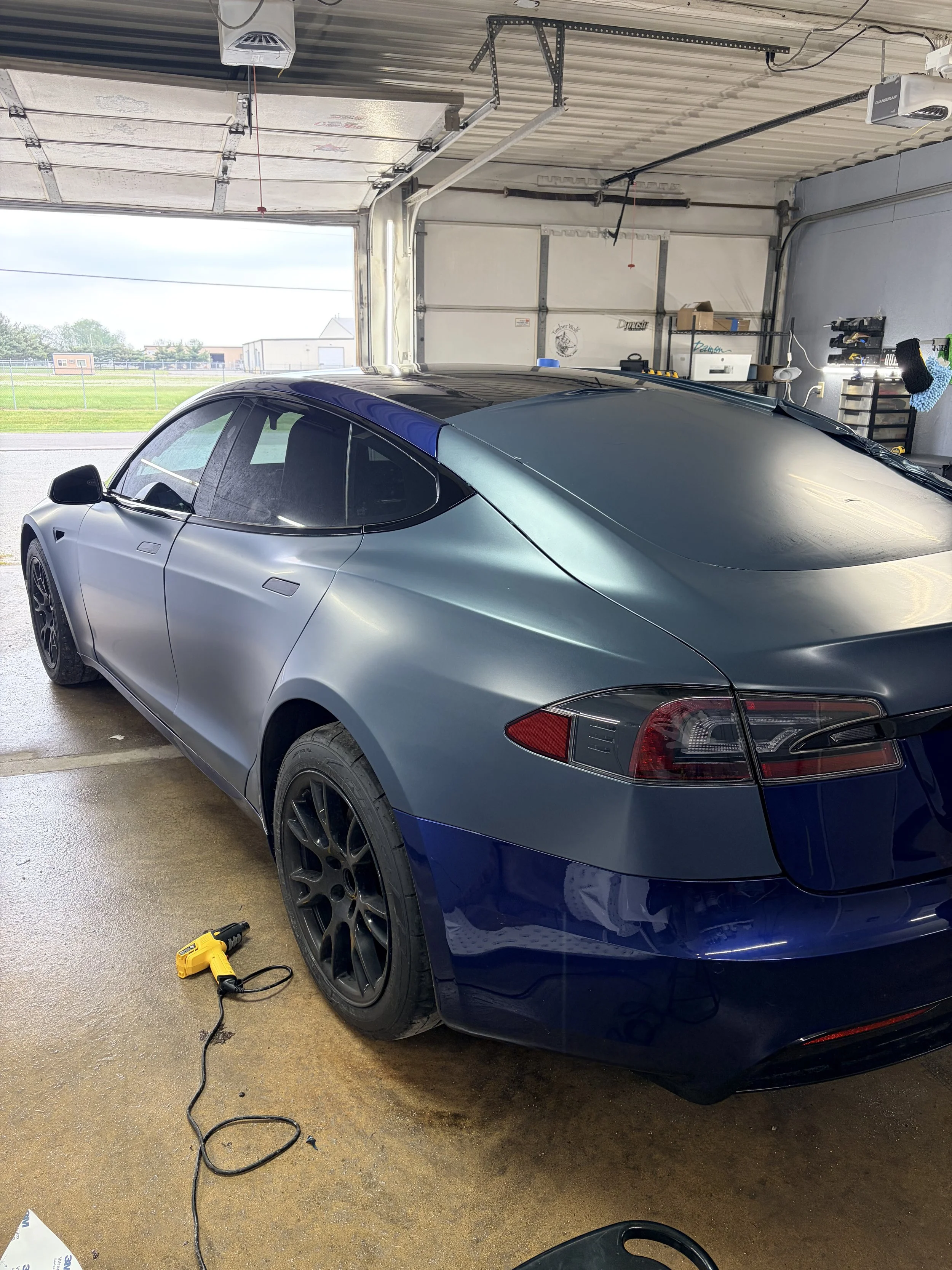 Jaden vinyl wrapping a Tesla Model S Plaid.