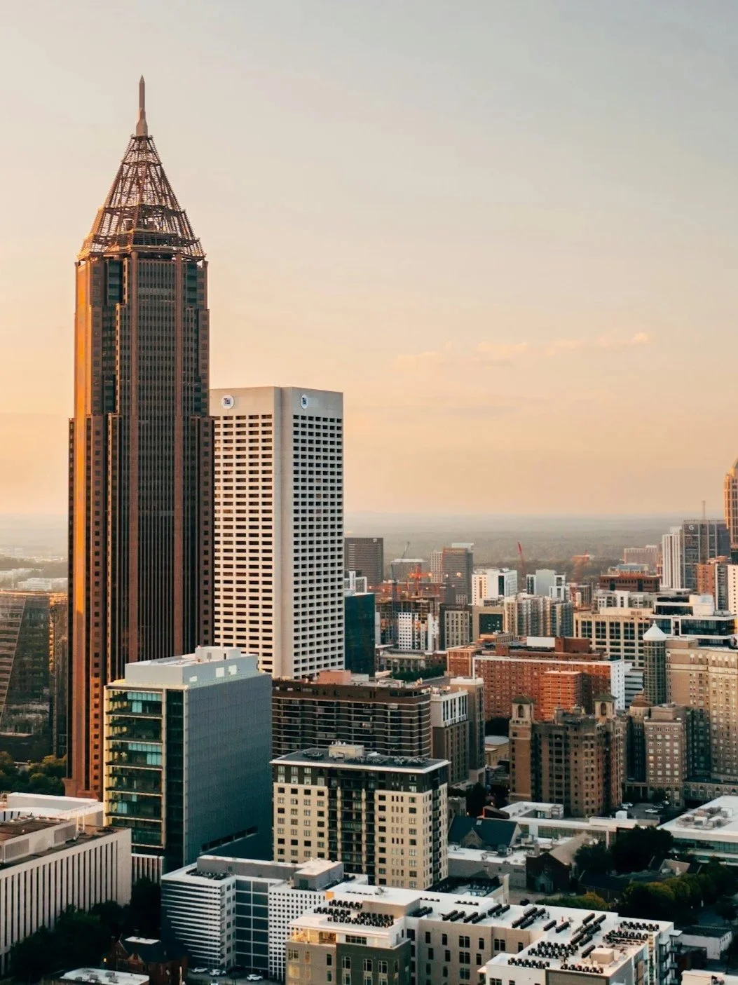 City skyline with tall skyscrapers during sunset in Atlanta with a clear sky and horizon.