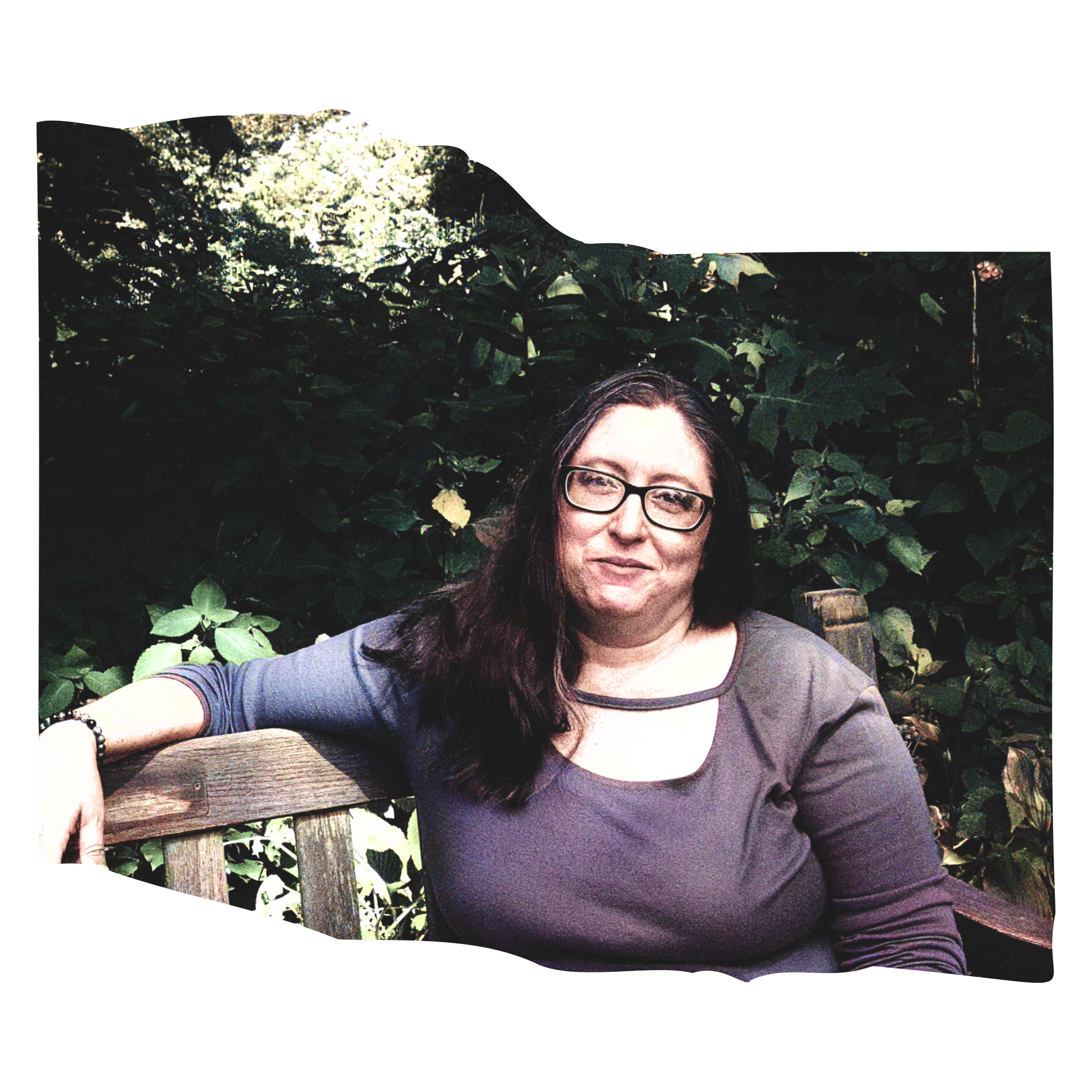 Stephanie Pitcher Whittier sits on a park bench wearing a purple shirt.