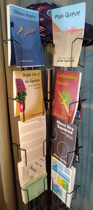Photograph of a wire rack, holding test prints of stories by Brian Garrison.