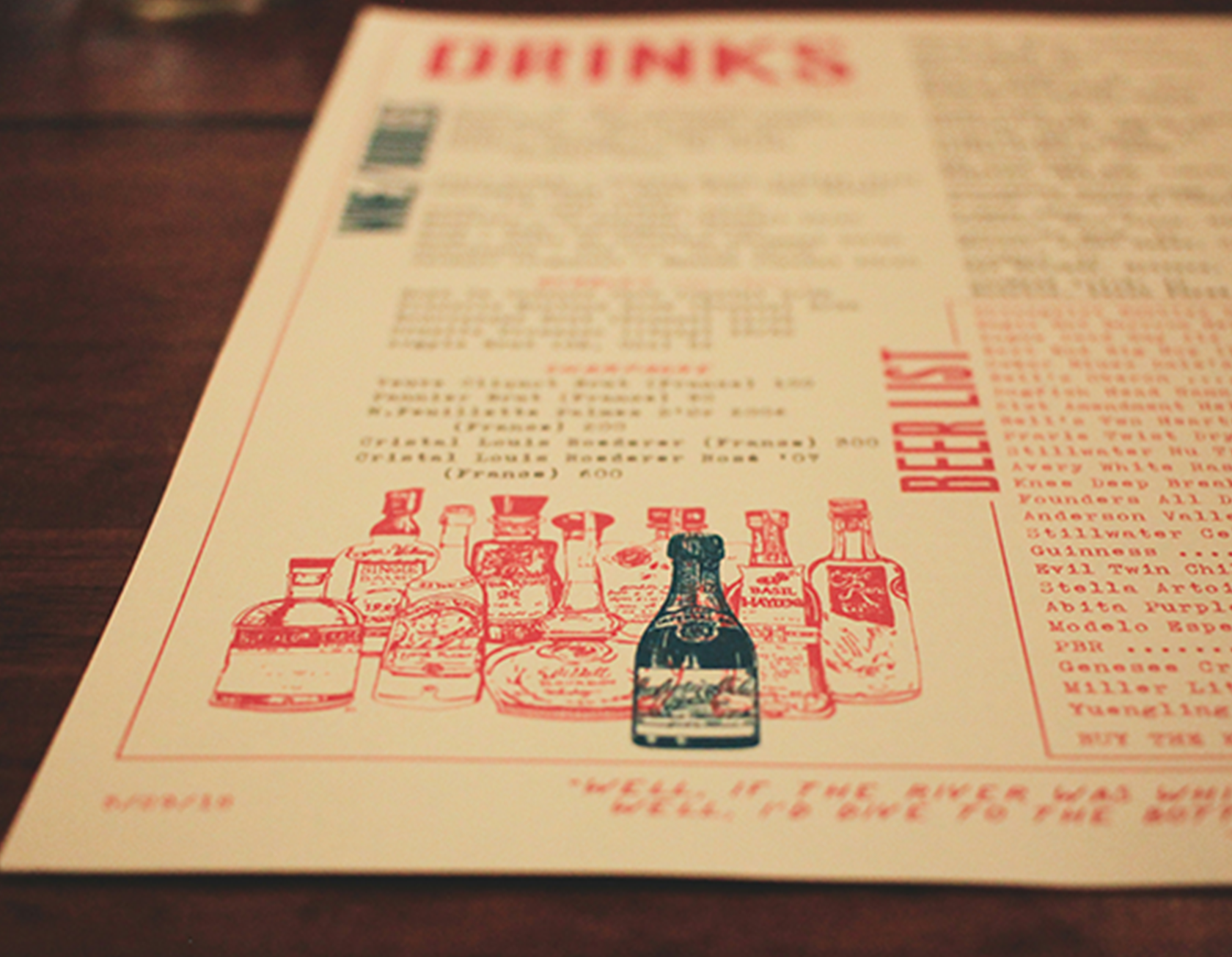 A close-up of a takeout menu on a wooden table, featuring a list of beverages and some illustrated bottles at the bottom.
