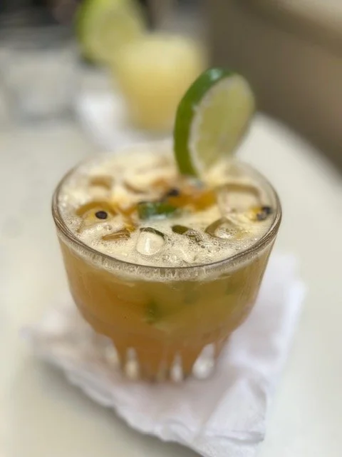 Glass of iced cocktail garnished with a lime wedge