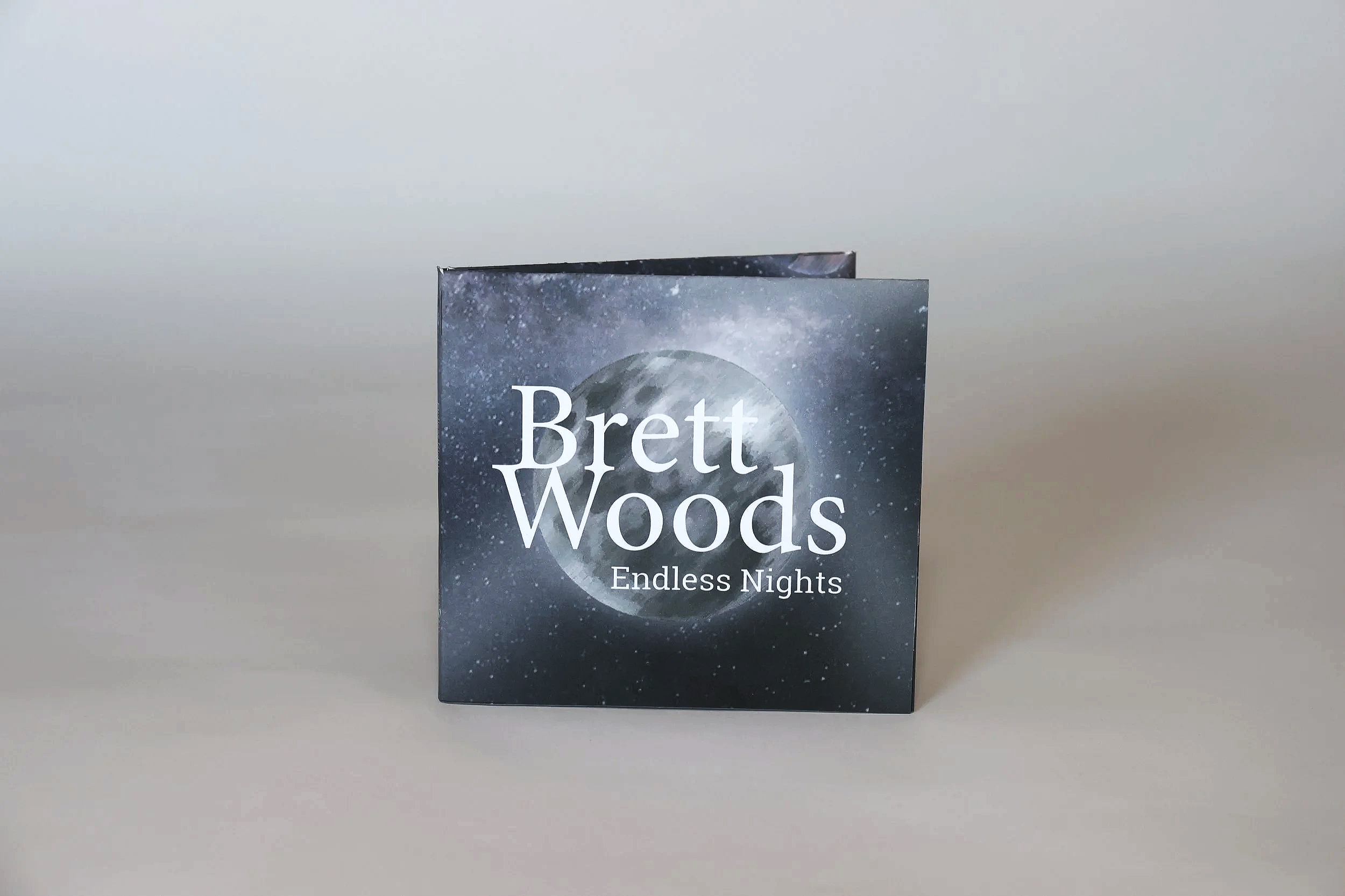 This is an image of packaging for the CD of a fictional artist, Brett Woods. This particular album is called Endless Nights and has a space aesthetic on the cover of the CD packaging.