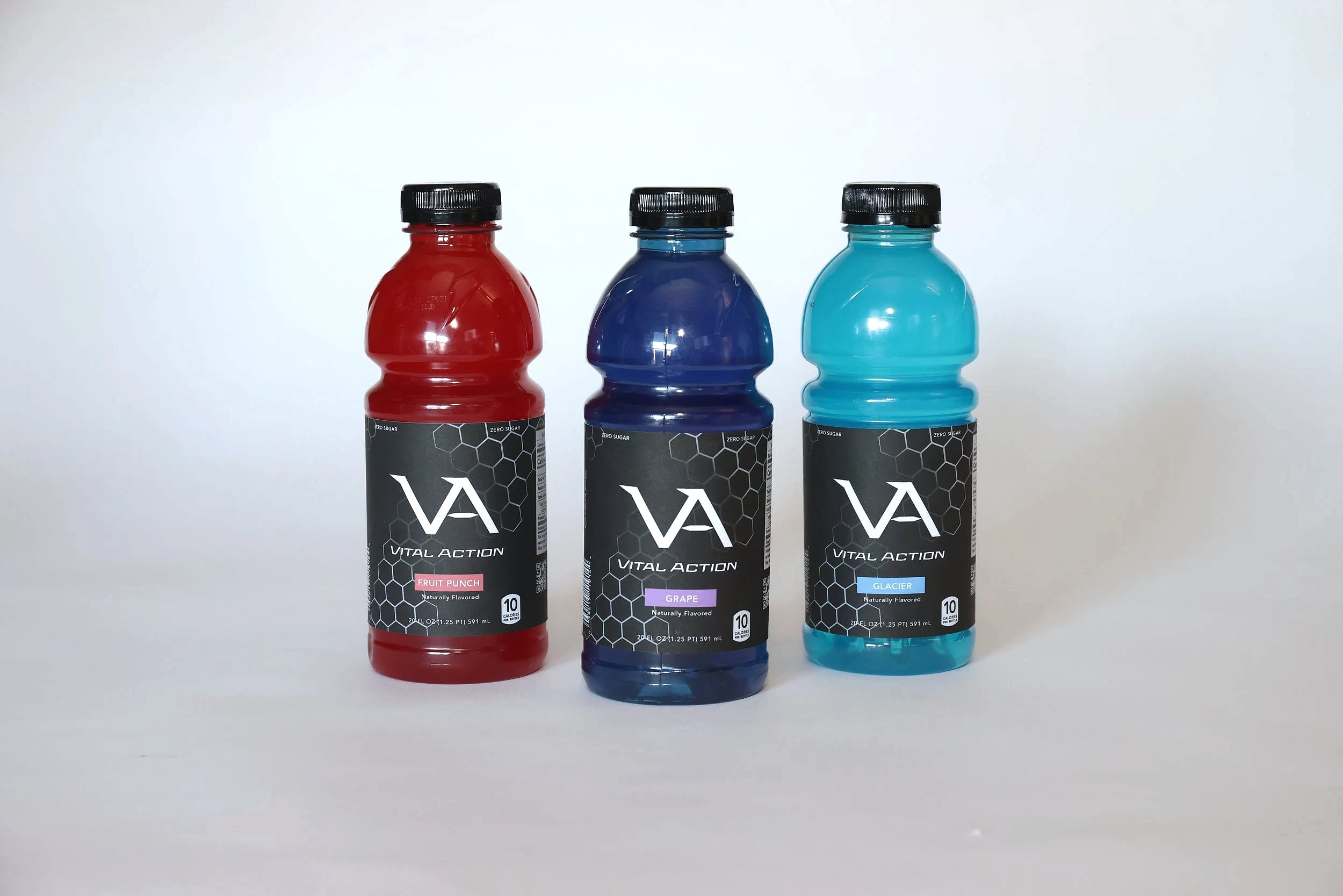 This is an image of packaging for a fictional sports drink brand called Vital Action. The image has three different flavors of the brand, one fruit punch (Red), one grape (Purple), and one Glacier (Blue).