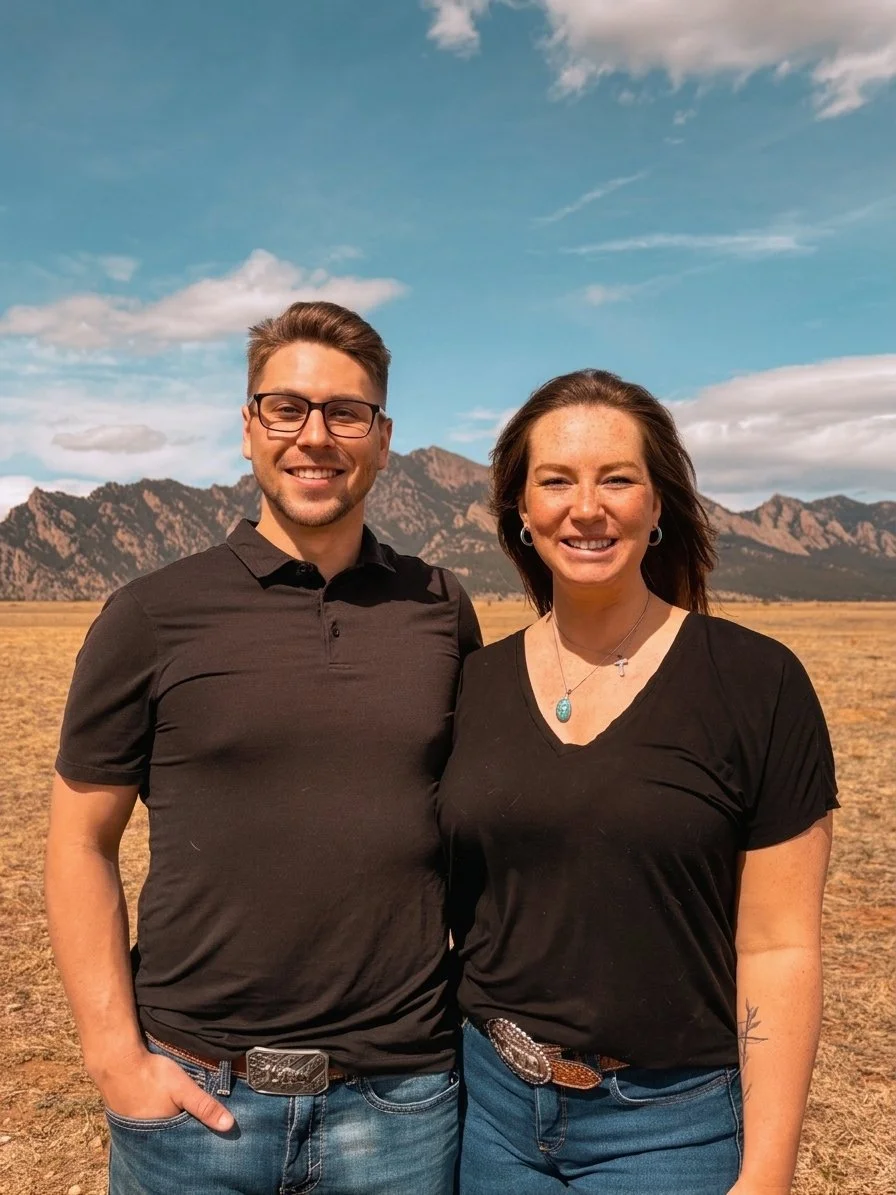 Dr. Ian, D.C. and Dr. Emma, D.C., IVCA stand in a field in front of the Flatiron Mountains near Westminster, CO