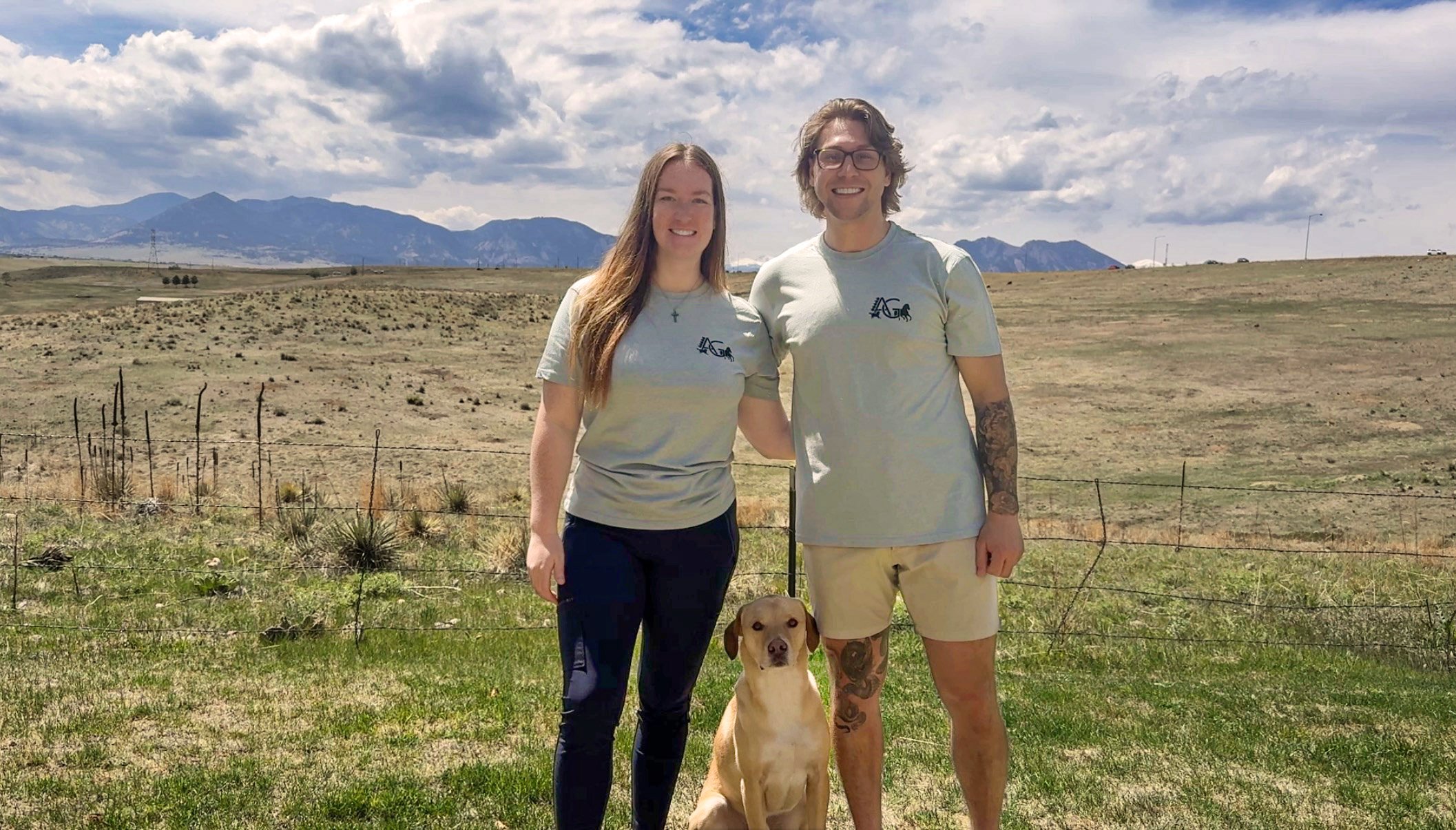 Dr. Emma, Dr. Ian, and their dog Buddy stand with the Flatiron Mountains in the background near Westminster, CO