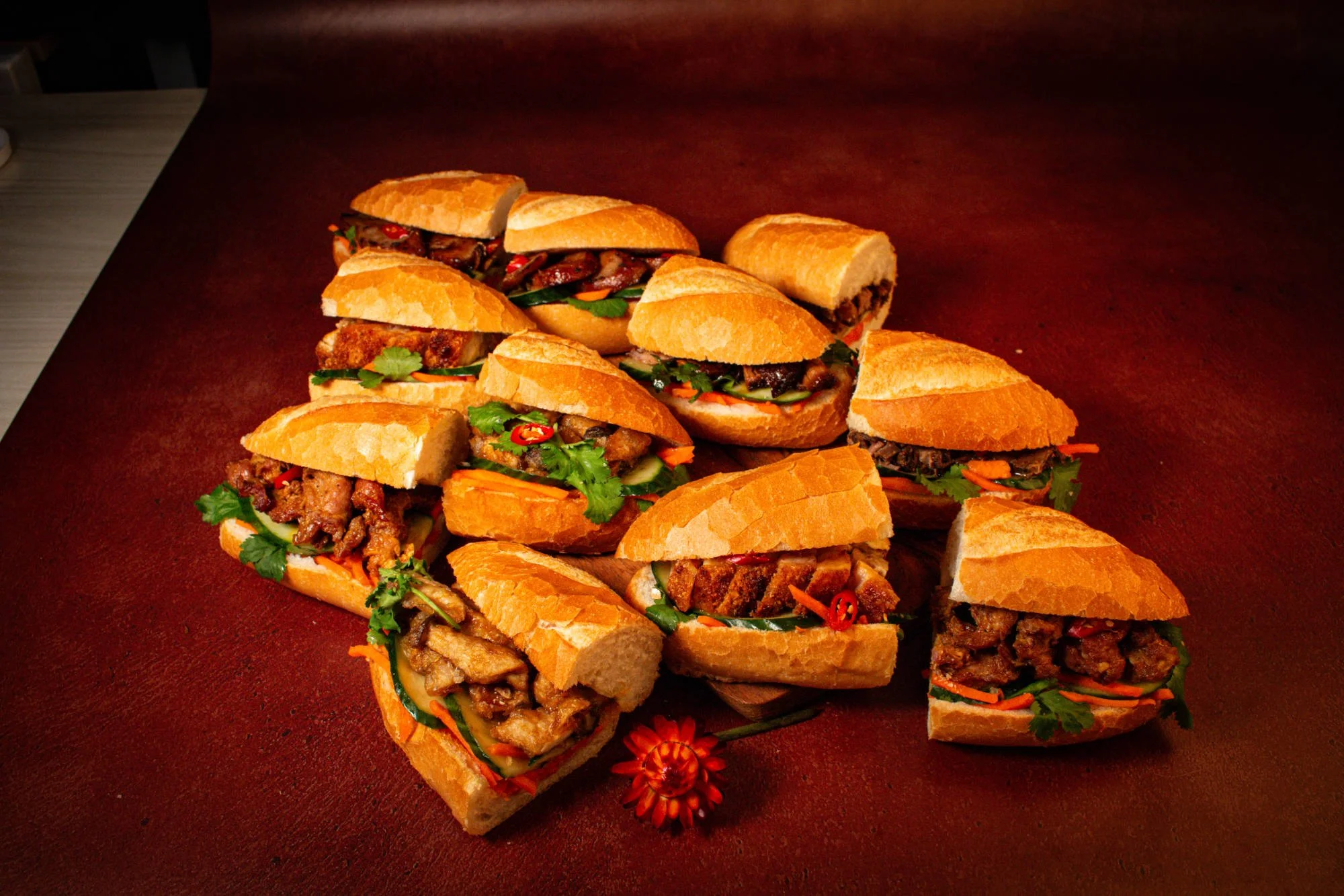 Several cut sandwiches with meat, vegetables, and herbs