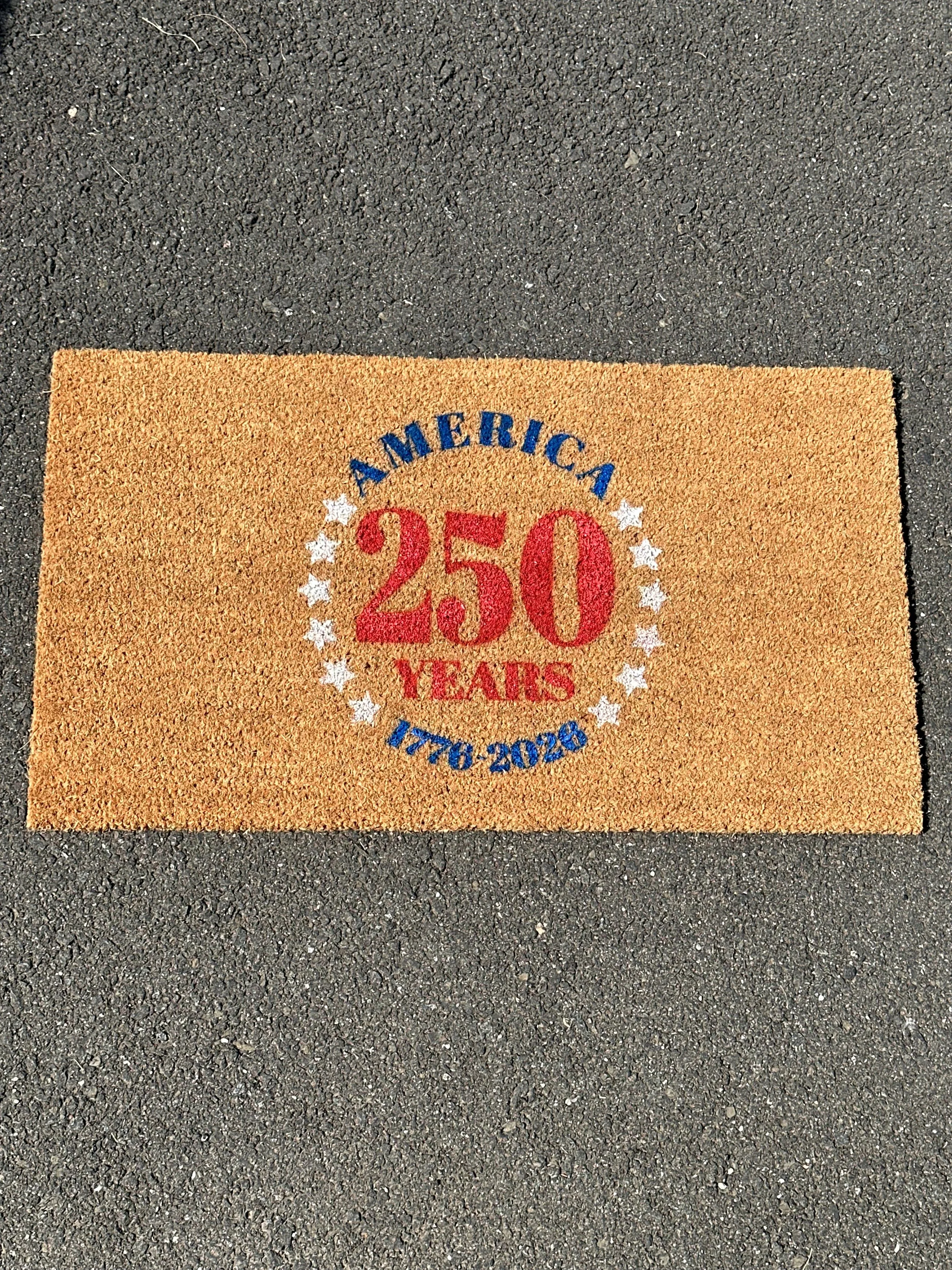 17 inch by 30 inch America 250 years coir doormat with red white and blue design