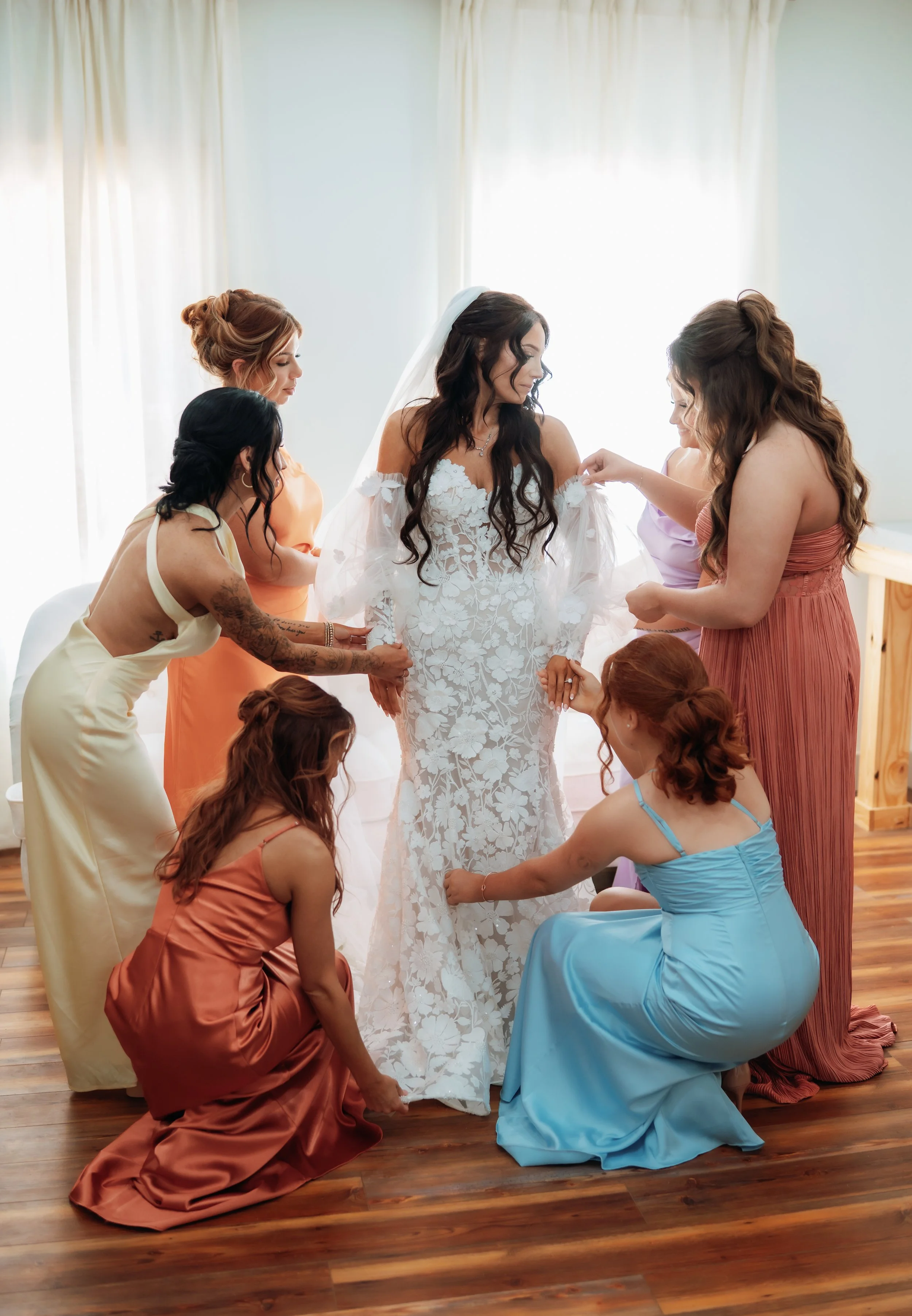Laurie’s customers, Mariana and Carmen holding hands on a green lawn on their wedding day.