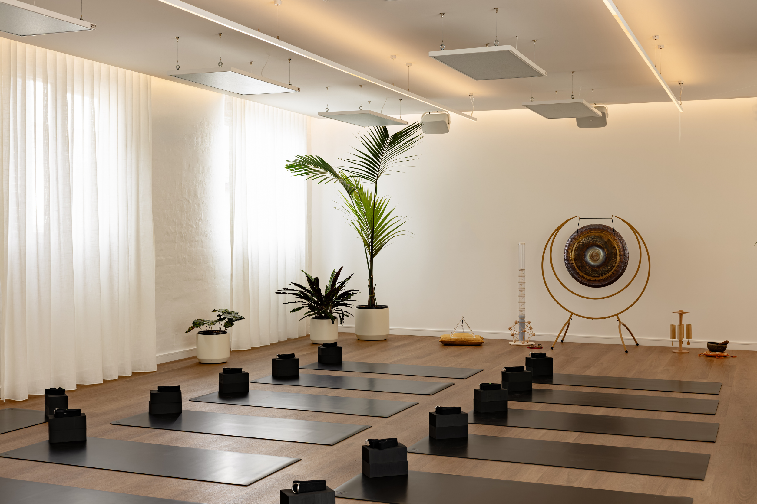 Light-filled yoga practice space at Flow Republic, a premium yoga studio in Rozelle, Sydney, featuring modern yoga mats, props, sound healing instruments and calming interiors.