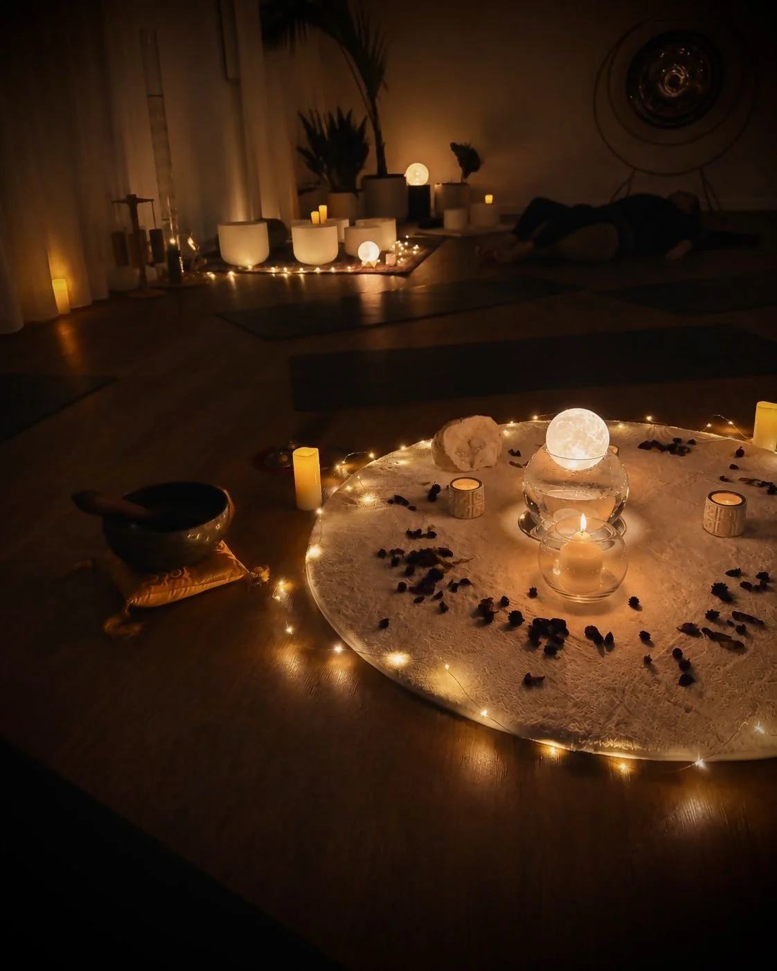 Flow Republic studio set up for the Full Moon Gathering special event, with yoga mats, singing bowls, candles and a glowing moon centrepiece.
